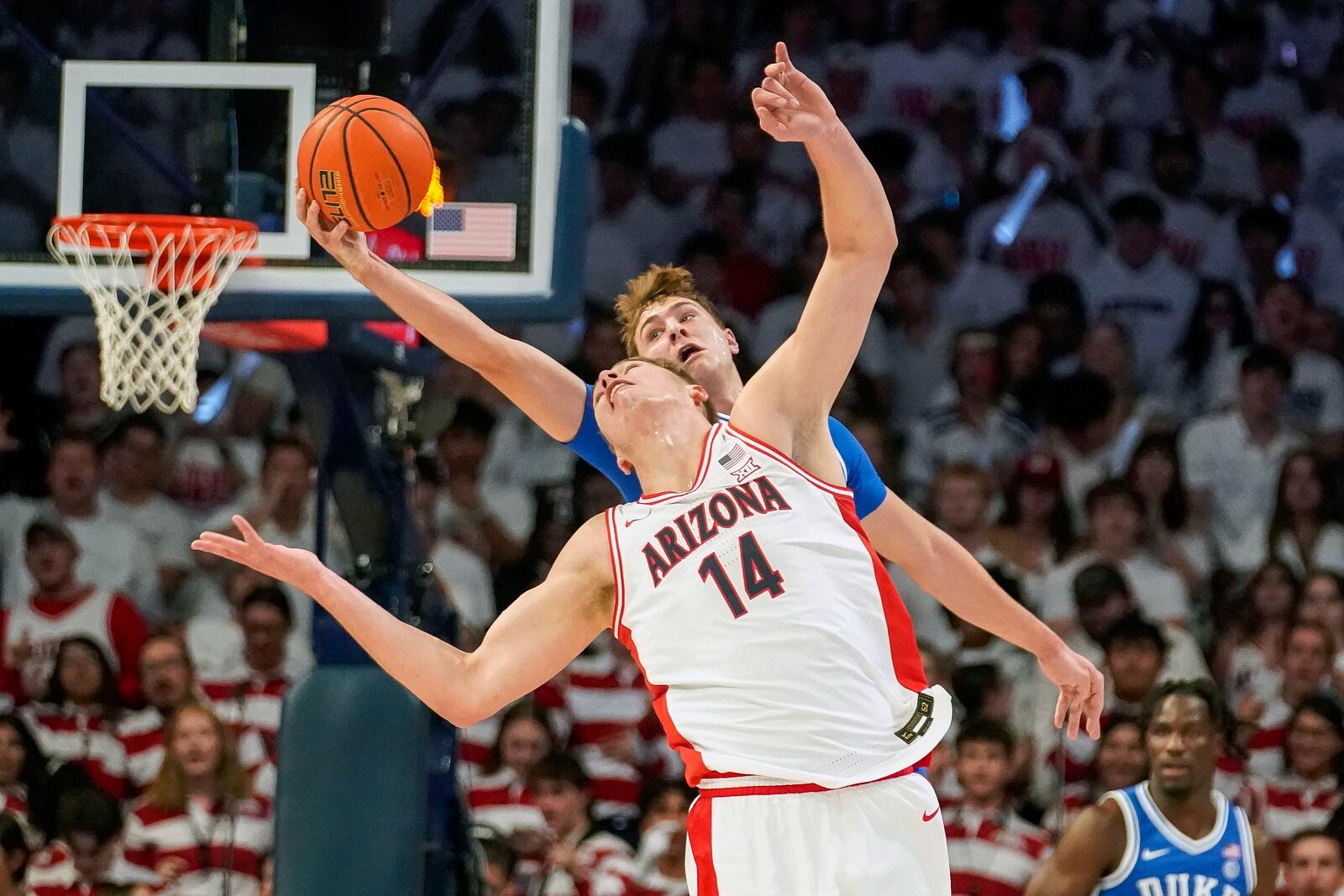 Duke guard Cooper Flagg, rear, picks off a pass intended for Arizona's Motiejus Krivas (14) during the first half of an NCAA college basketball game Friday, Nov. 22, 2024, in Tucson, Ariz. (AP Photo/Darryl Webb)