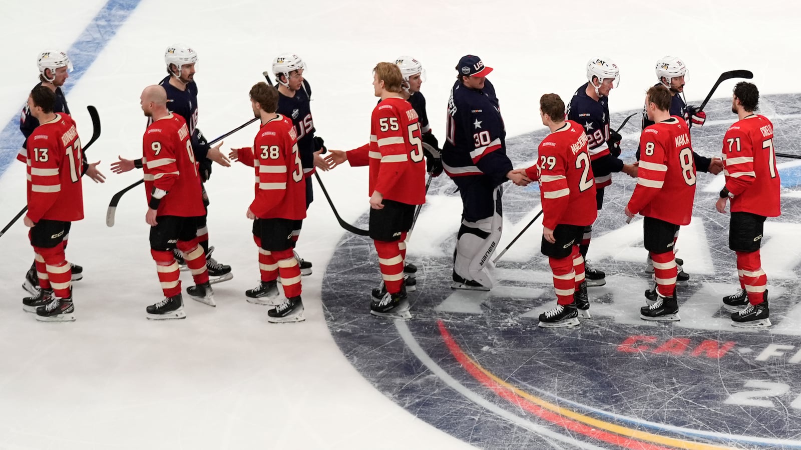 Canada, bottom, and United States, top, players shake hands following an overtime period of the 4 Nations Face-Off championship hockey game, Thursday, Feb. 20, 2025, in Boston. (AP Photo/Charles Krupa)