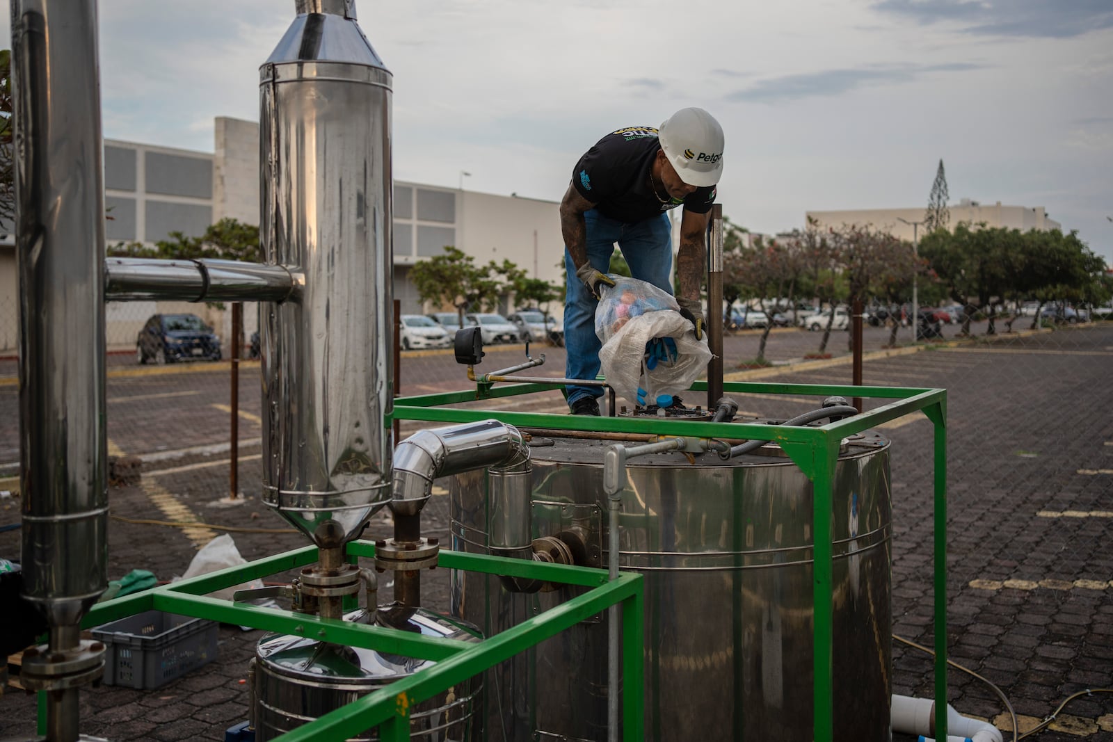 Jesus Cuevas, a Petgas technician, throws plastic into Petgaserita, a non-catalytic pyrolysis machine, to convert it into fuel, in Boca del Rio, Veracruz, Mexico, Jan. 4, 2025. (AP Photo/Felix Marquez)