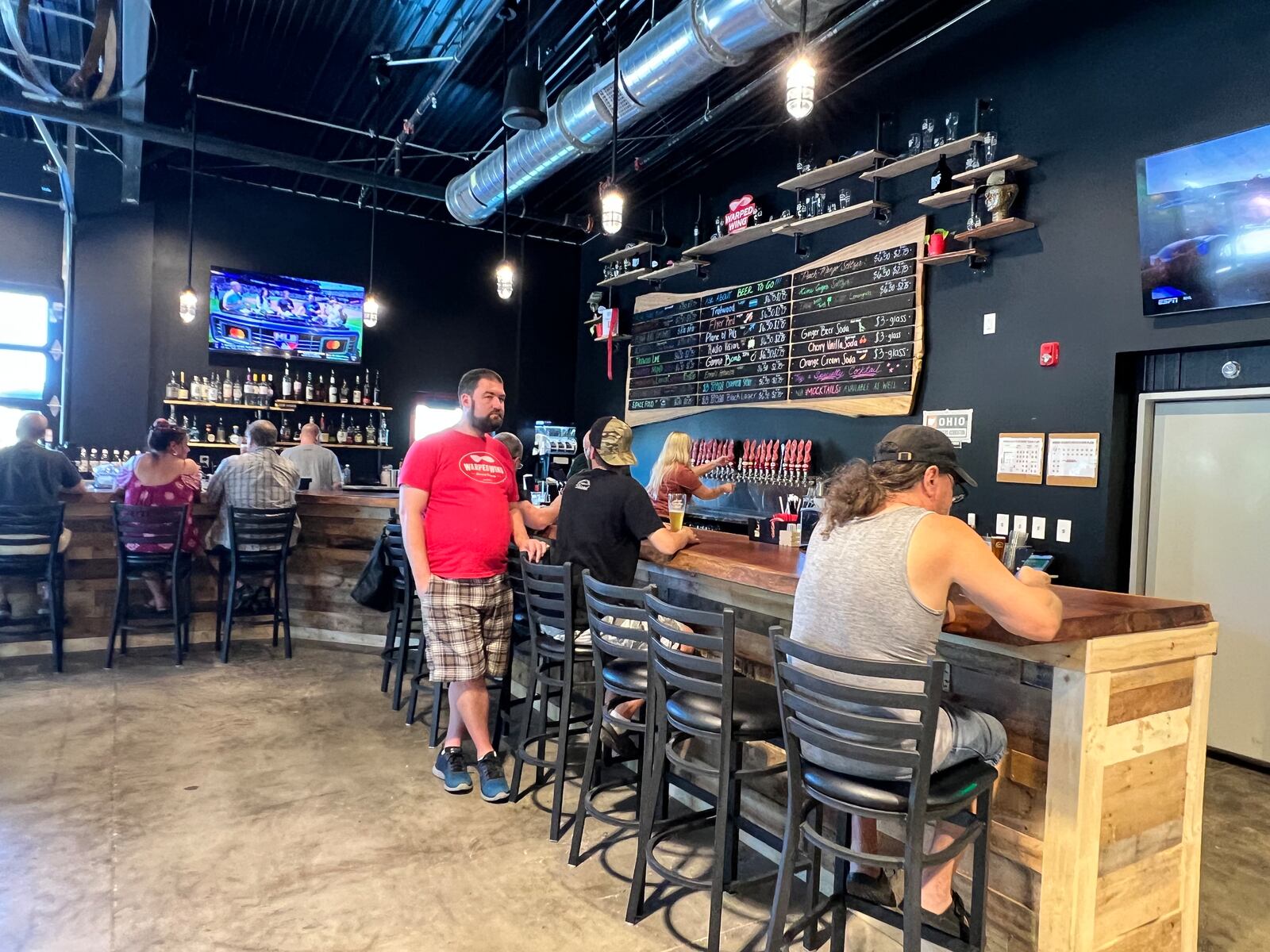 Televisions line the walls throughout Warped Wing Brewery & Smokery in Huber Heights. ALEXIS LARSEN