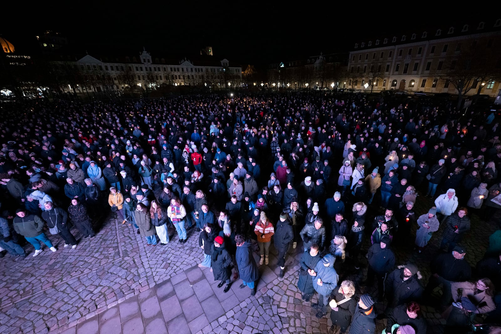 Participants in a silent prayer stand with candles in the Cathedral Square Magdeburg, Germany, Saturday Dec. 21, 2024 for the victims when a car drove into the crowds at the Christmas market on Friday. (Sebastian Kahnert/DPA via AP)