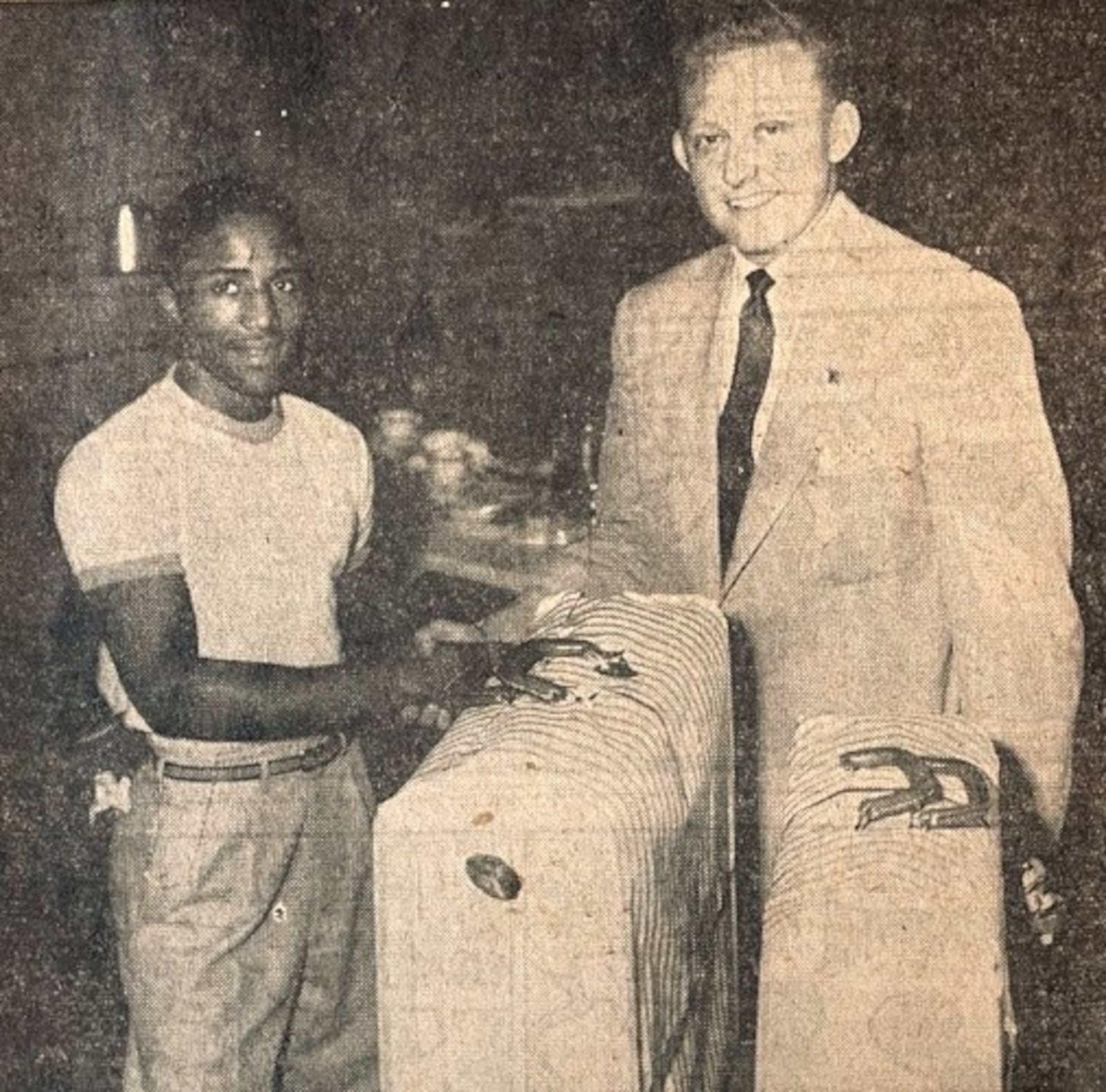 Champion boxer Davey Moore, nicknamed “The Springfield Rifle,” was a member of the U.S. Olympic team that traveled to Helsinki in 1952. He is shown here in the summer of 1952 during a luncheon meeting for the Junior Chamber of Commerce at the Hotel Shawnee. There, the president of the Jaycees, Bob Acton, presented him with a two-piece luggage set to carry his clothing and equipment to the games. Moore boxed as a bantamweight at the Olympics, making it to the quarter finals.