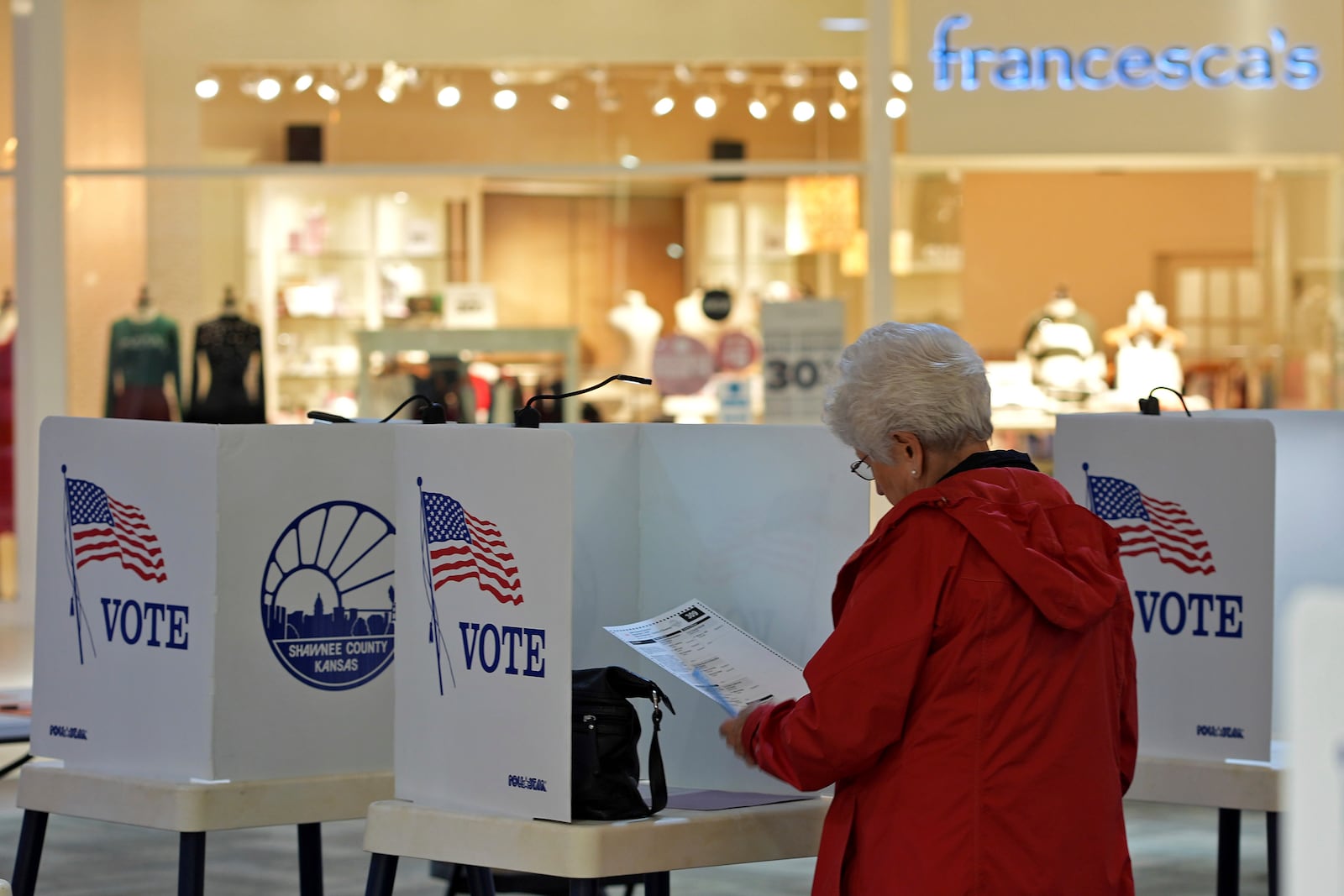 Delores Engel looks over her ballot while voting at the West Ridge Mall Tuesday, Nov. 5, 2024, in Topeka, Kan. (AP Photo/Charlie Riedel)