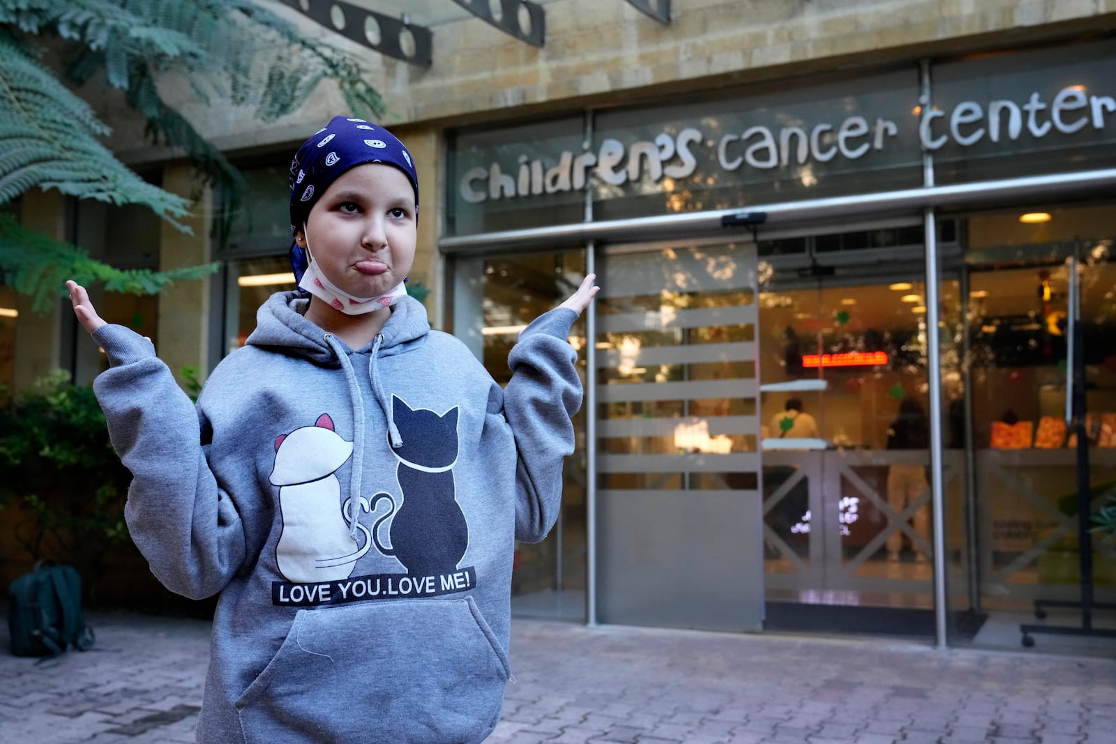 Asinat al Lahham, 9, a Syrian-Palestinian girl who escaped the war in Syria with her family and who suffers from leukaemia, gestures outside the Children's Cancer Center of Lebanon, in Beirut, Lebanon, Friday, Nov. 15, 2024. (AP Photo/Hussein Malla)