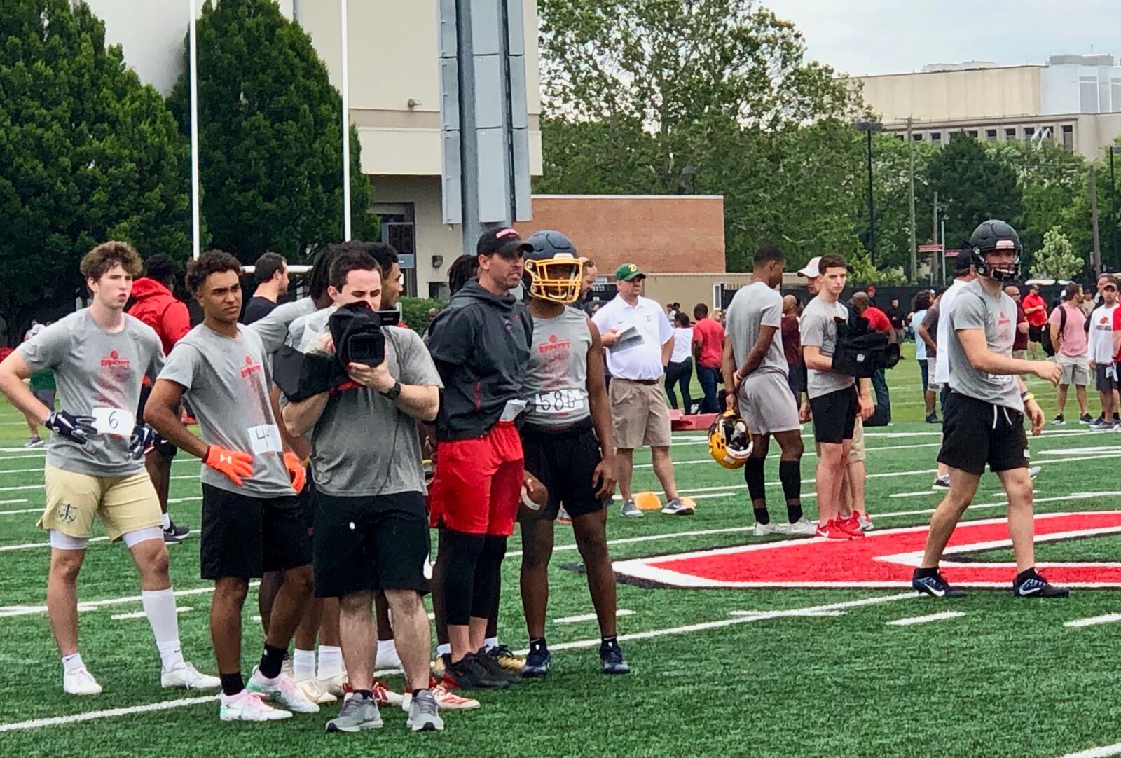 Springfield QB Te'Sean Smoot (blue helmet with gold facemask) speaks to Ohio State WRs coach Brian Hartline at Ohio State's camp June 15.