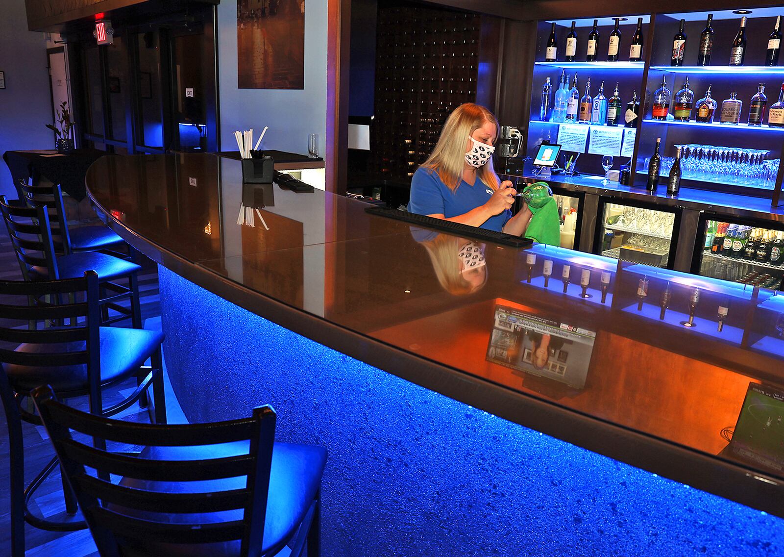 Rhiannon Fraley, an employee at Stella Bleu Bistro gets the bar ready for the evening crowd Tuesday. BILL LACKEY/STAFF