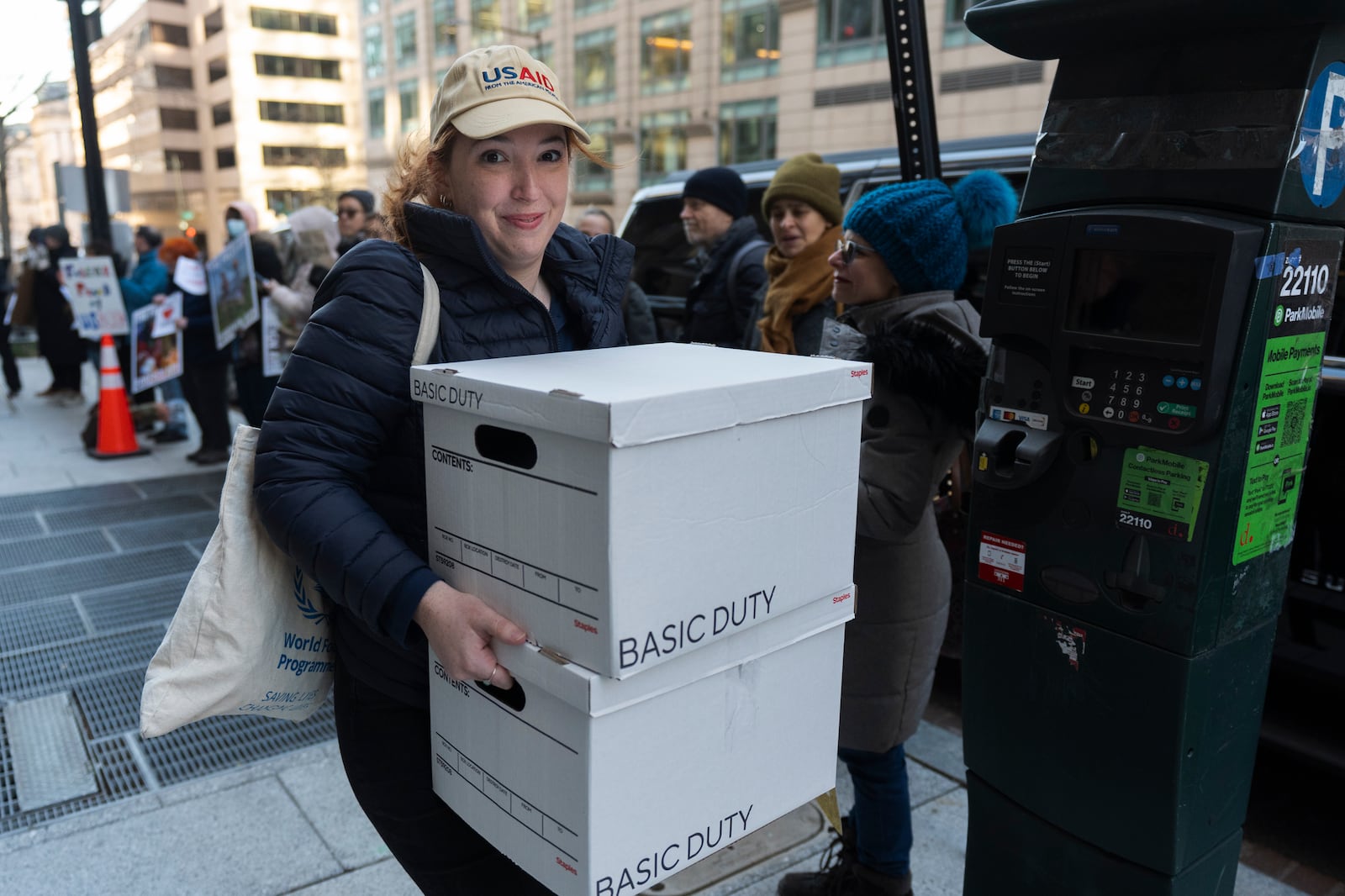 A United States Agency for International Development worker, carries her personal belongings after retrieving them from the USAID's Bureau of Humanitarian Affairs office in Washington, Friday, Feb. 21, 2025, in Washington. (AP Photo/Manuel Balce Ceneta)