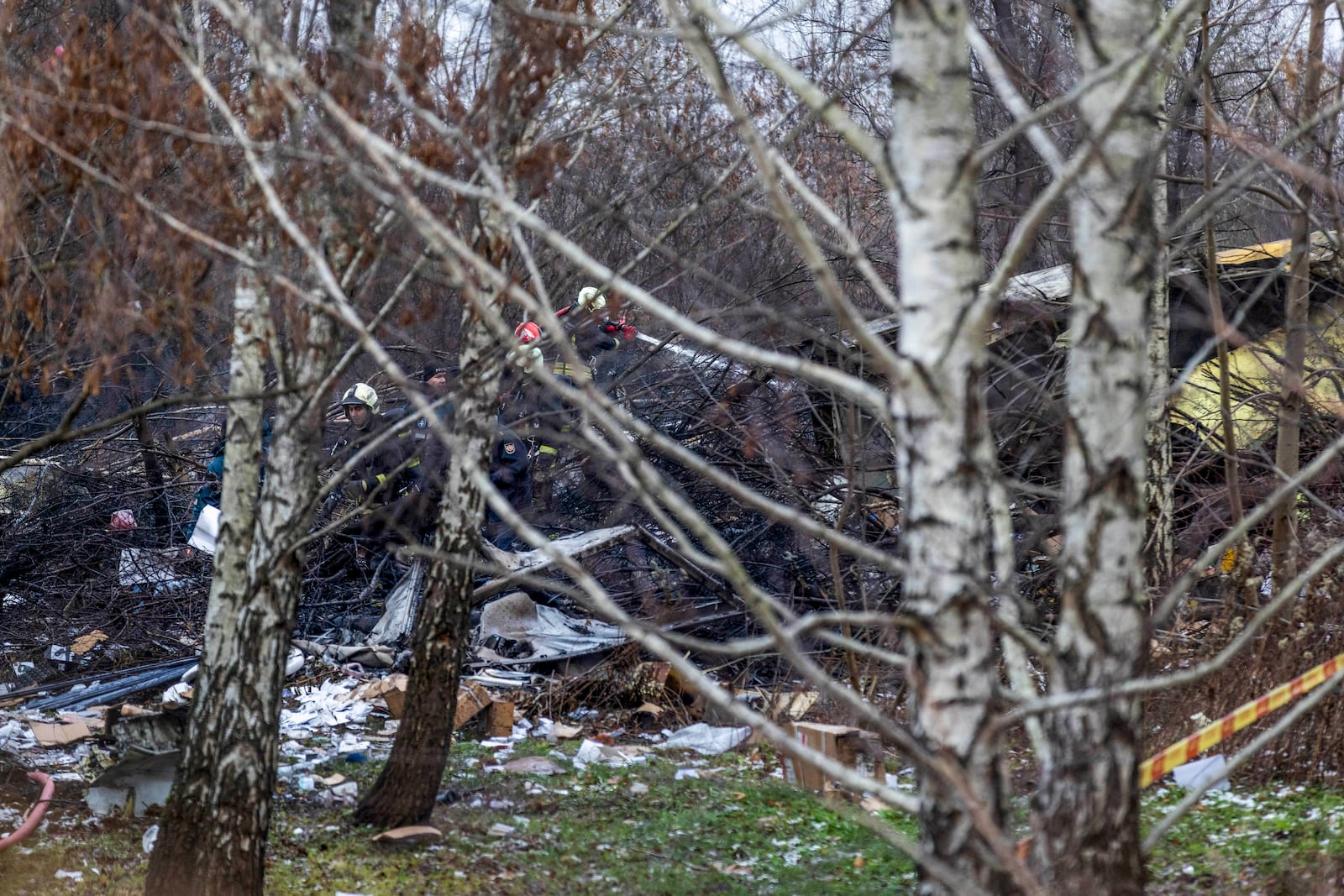 Lithuanian Emergency Ministry employees work near the site where a DHL cargo plane crashed into a house near the Lithuanian capital Vilnius, Lithuania, Lithuania, Monday, Nov. 25, 2024. (AP Photo/Mindaugas Kulbis)