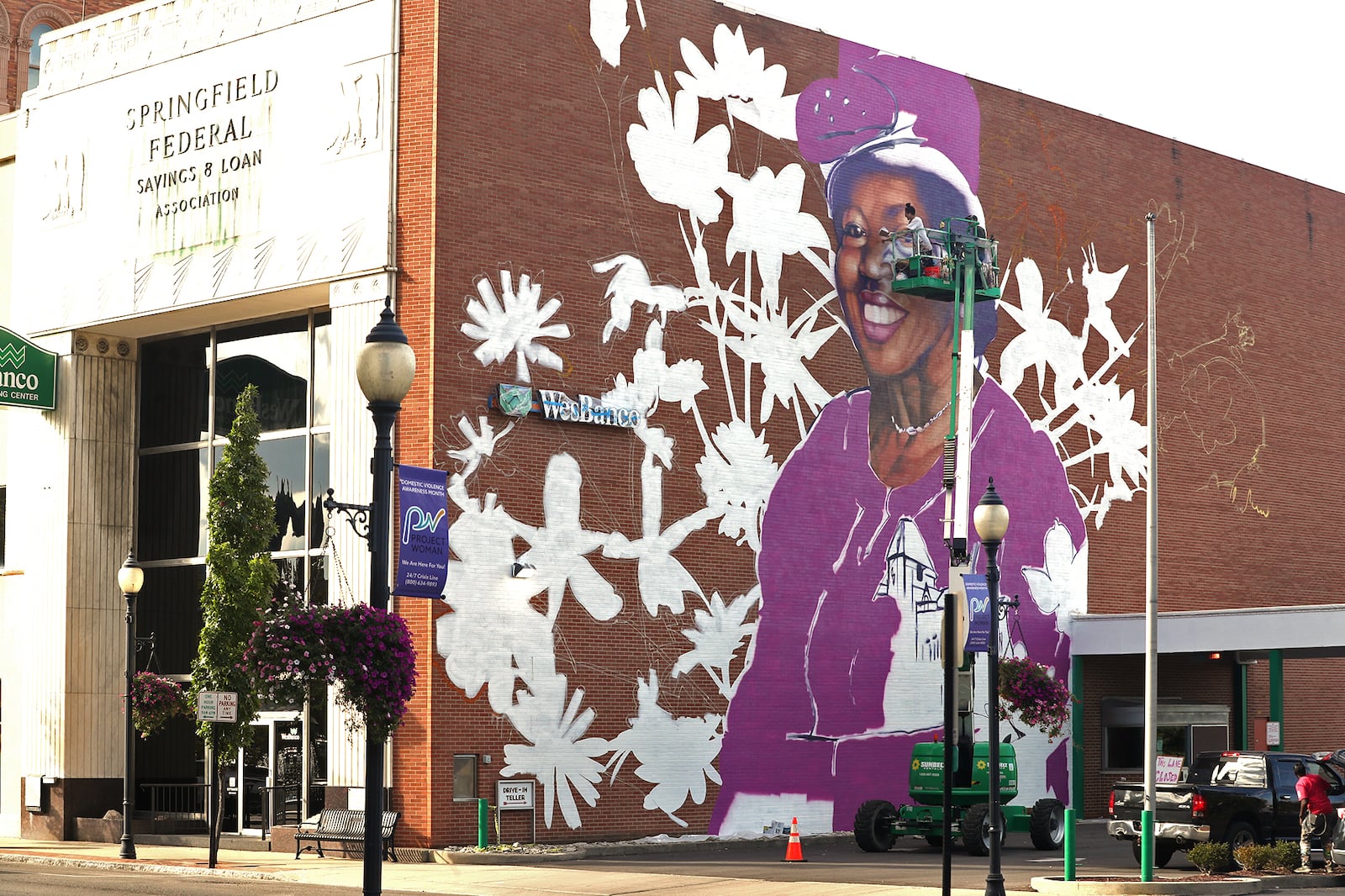 Muralist Gaia, from New York City, works on the mural of Springfield civil rights advocate Hattie Moseley on Thursday, Oct. 6, 2022 on the side of the WesBanco building in downtown Springfield. BILL LACKEY/STAFF