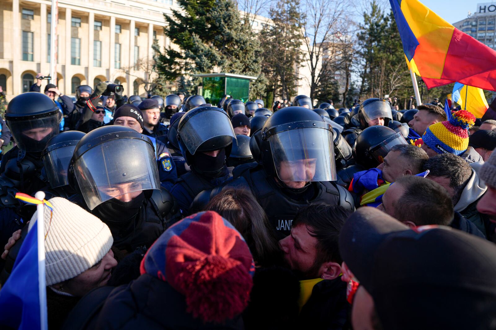 Riot police scuffle with supporters of Calin Georgescu, the winner of Romania's first round of presidential election which the Constitutional Court later annulled, who broke through police lines in front of the government headquarters, in Bucharest, Romania, Monday, Feb. 10, 2025. (AP Photo/Vadim Ghirda)