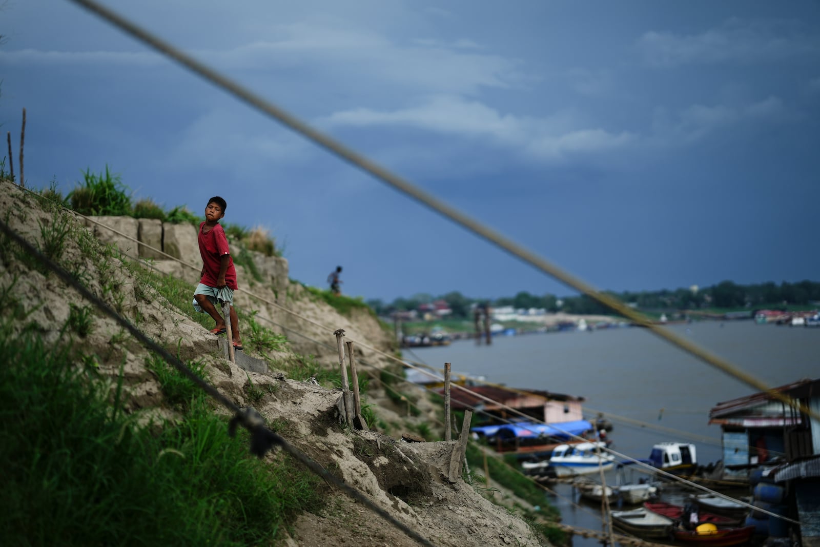 A boy climbs a hill near a low Amazon River due to the drought, in Leticia, Colombia, Sunday, Oct. 20, 2024. (AP Photo/Ivan Valencia