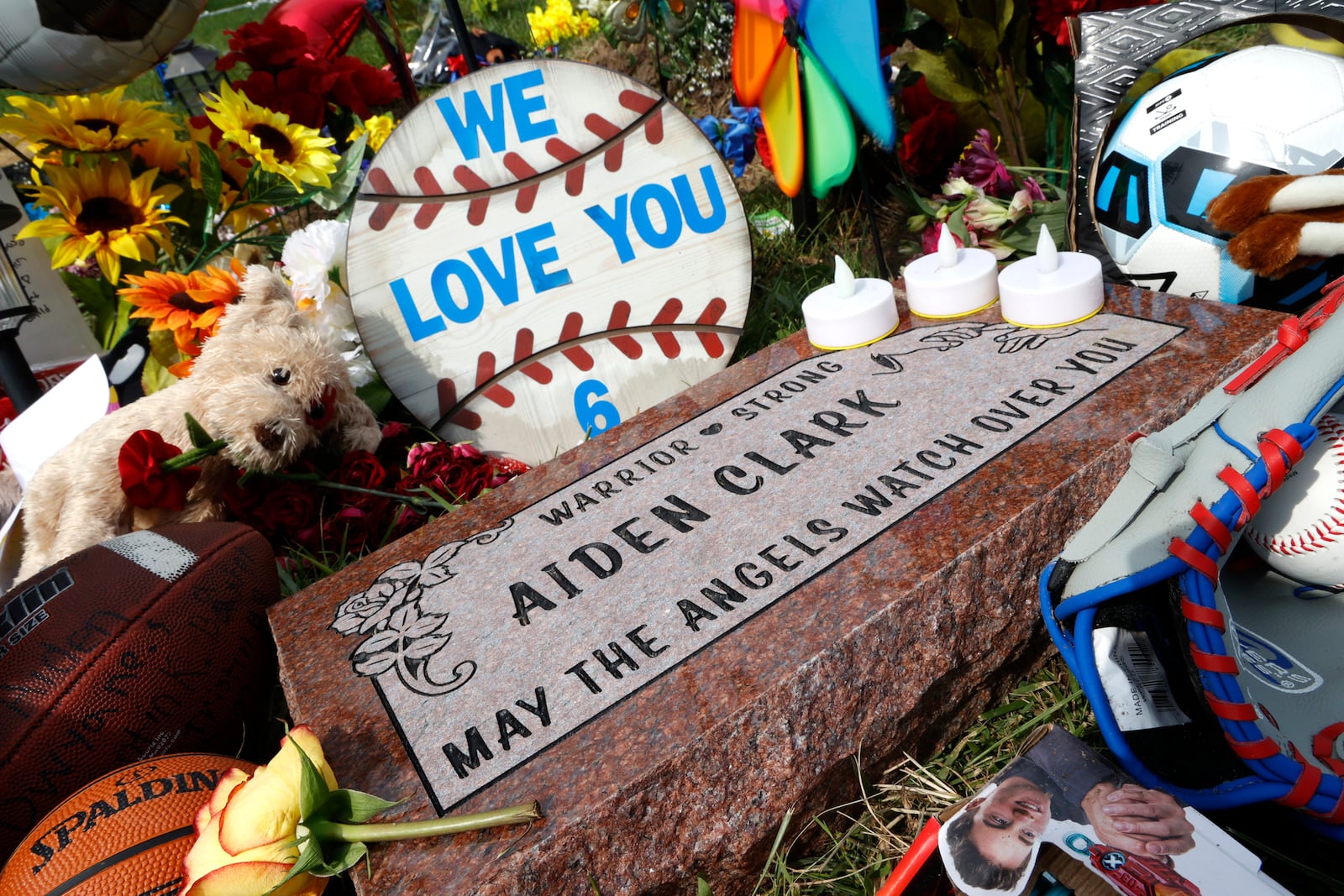 A granite marker for Aiden Clark is among the items that make up the memorial along Troy Road Thursday, August 24, 2023 for the victims of Tuesday's Northwestern school bus crash. BILL LACKEY/STAFF