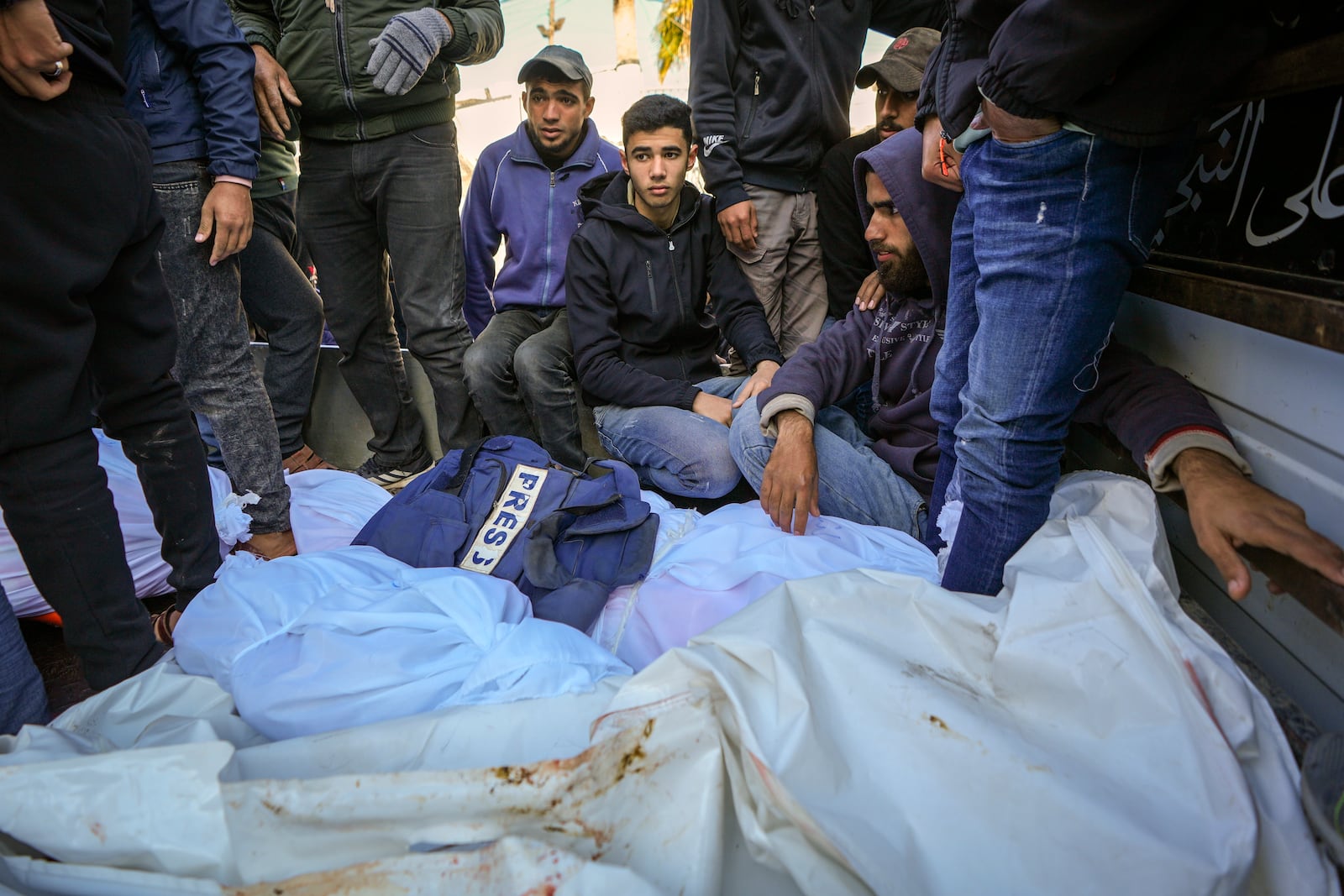 Colleagues and friends mourn over the body of freelance journalist Omar al-Derawi and other victims of overnight Israeli army strikes at multiple locations in central Gaza Strip, at Al-Aqsa Martyrs Hospital in Deir al-Balah, Friday, Jan. 3, 2025. According to Al-Aqsa Martyrs Hospital, 30 people, including 10 women and 7 children, were killed in several attacks overnight in central Gaza. (AP Photo/Abdel Kareem Hana)