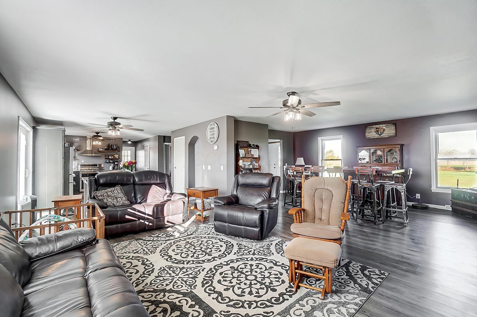 The living room has luxury vinyl tile flooring and is open to the both the kitchen and dining room.