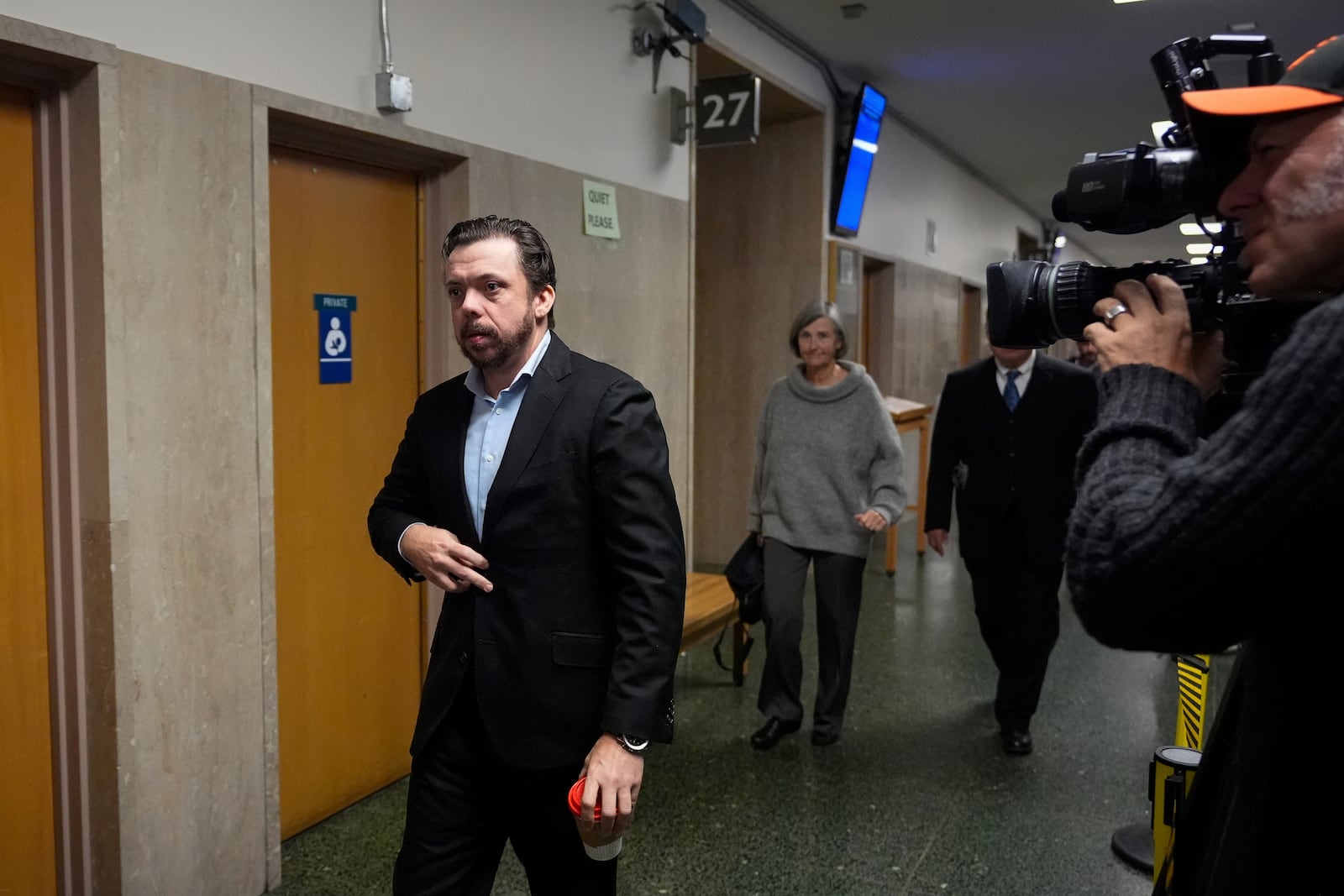 Timothy Oliver Lee, left, brother of Cash App founder Bob Lee, walks to Department 28 to enter the courtroom at the Hall of Justice for the murder trial of Nima Momeni, Tuesday, Dec. 3, 2024, in San Francisco. (AP Photo/Godofredo A. Vásquez)