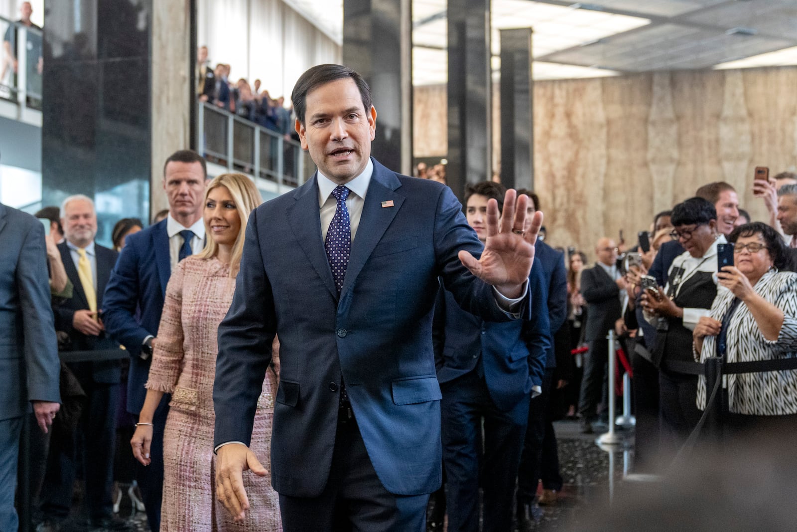 Secretary of State Marco Rubio greets people as he arrives to speak to State Department staff followed by his family, at the State Department, Tuesday, Jan. 21, 2025, in Washington. (AP Photo/Jacquelyn Martin)