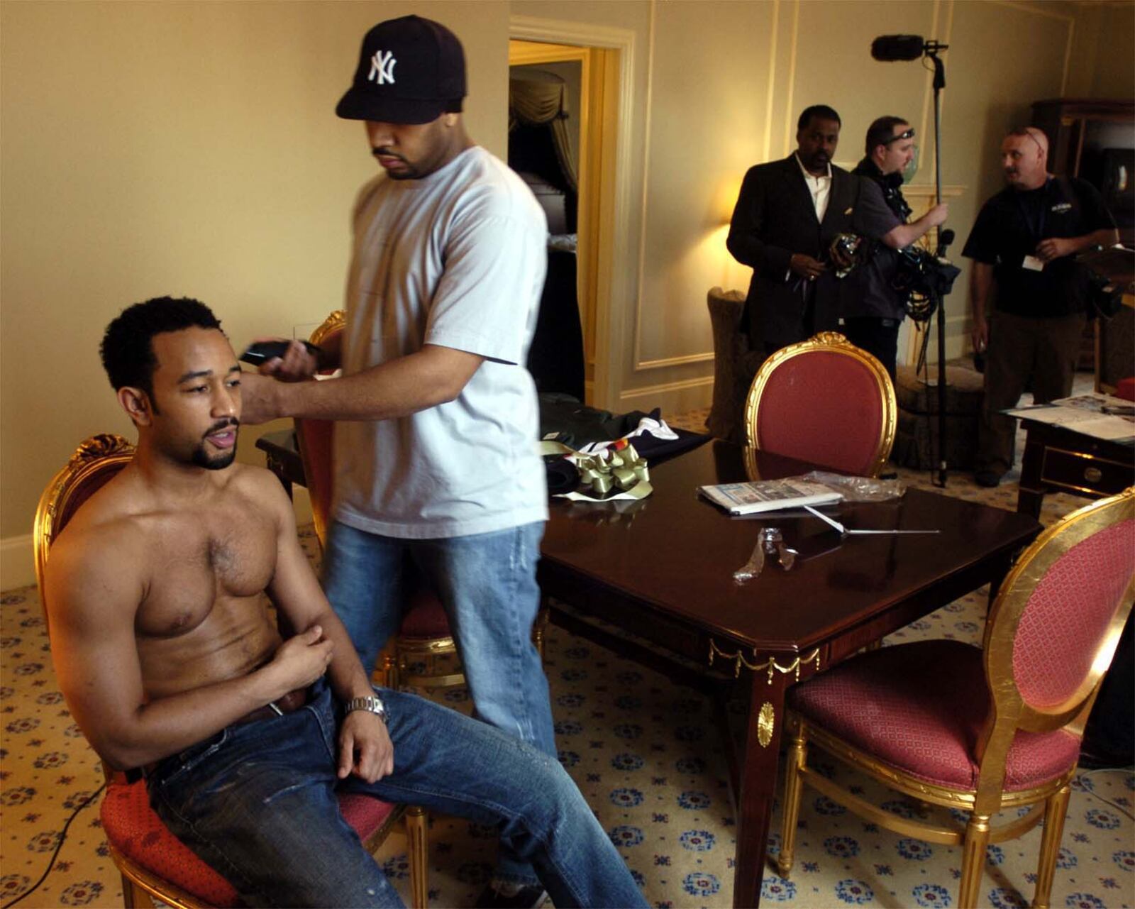 Springfield native John Legend gets a trim for the Grammy Awards from brother Ronald II as an "Access Hollywood" crew gets ready to tape in his Los Angeles hotel room in 2006. MARSHALL GORBY / STAFF