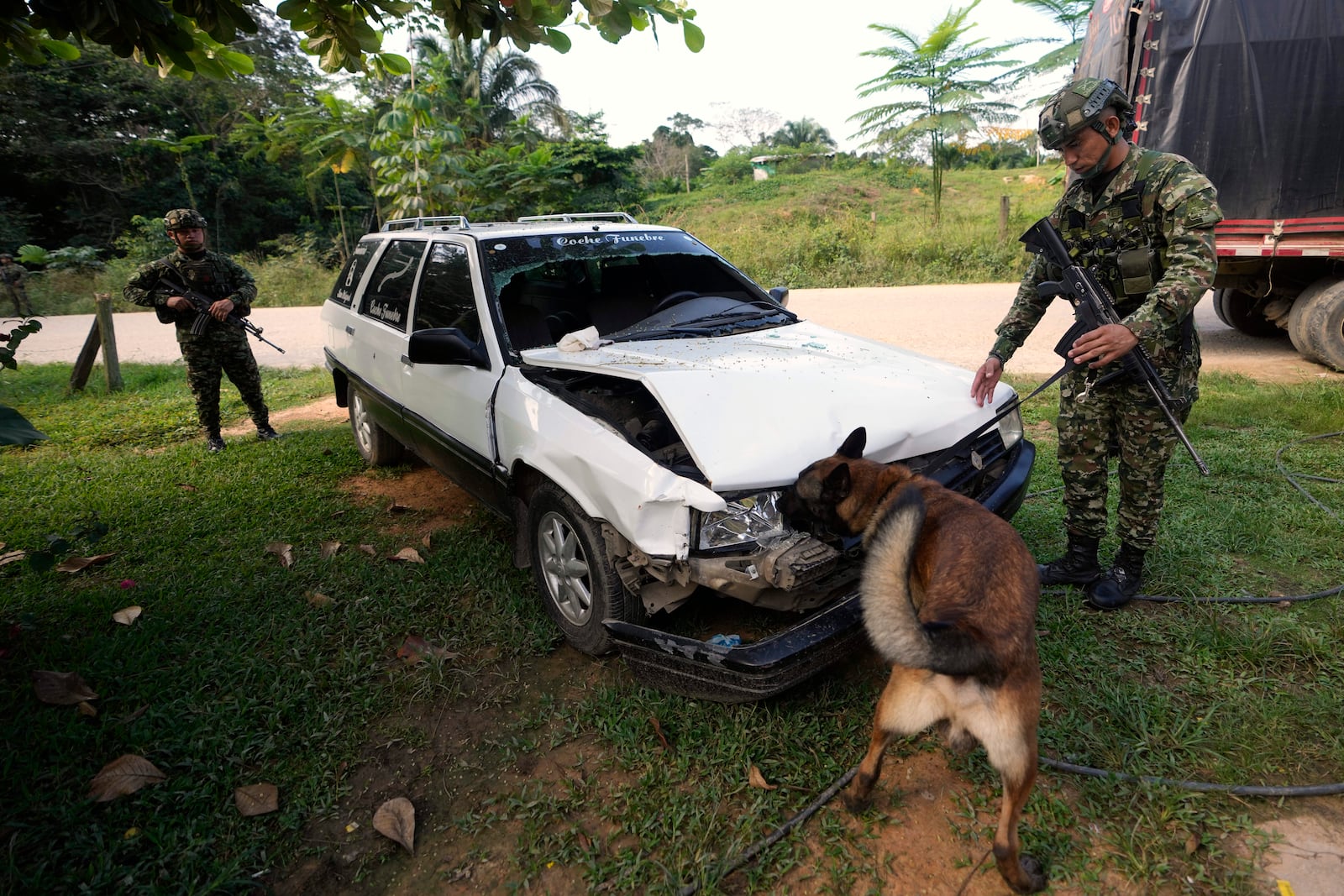 Soldiers inspect a car riddled with bullets where a family was shot and killed in Tibu, Colombia's northeastern Catatumbo region, where dozens have been killed amid clashes between the National Liberation Army (ELN) and former members of the Revolutionary Armed Forces of Colombia (FARC), Monday, Jan. 20, 2025. (AP Photo/Fernando Vergara)