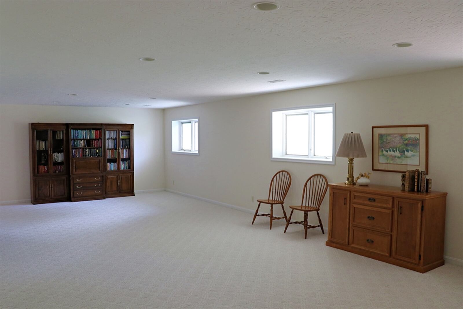 In the lower level of the home, the recreation room has daylight windows and an abundance of canister lights.