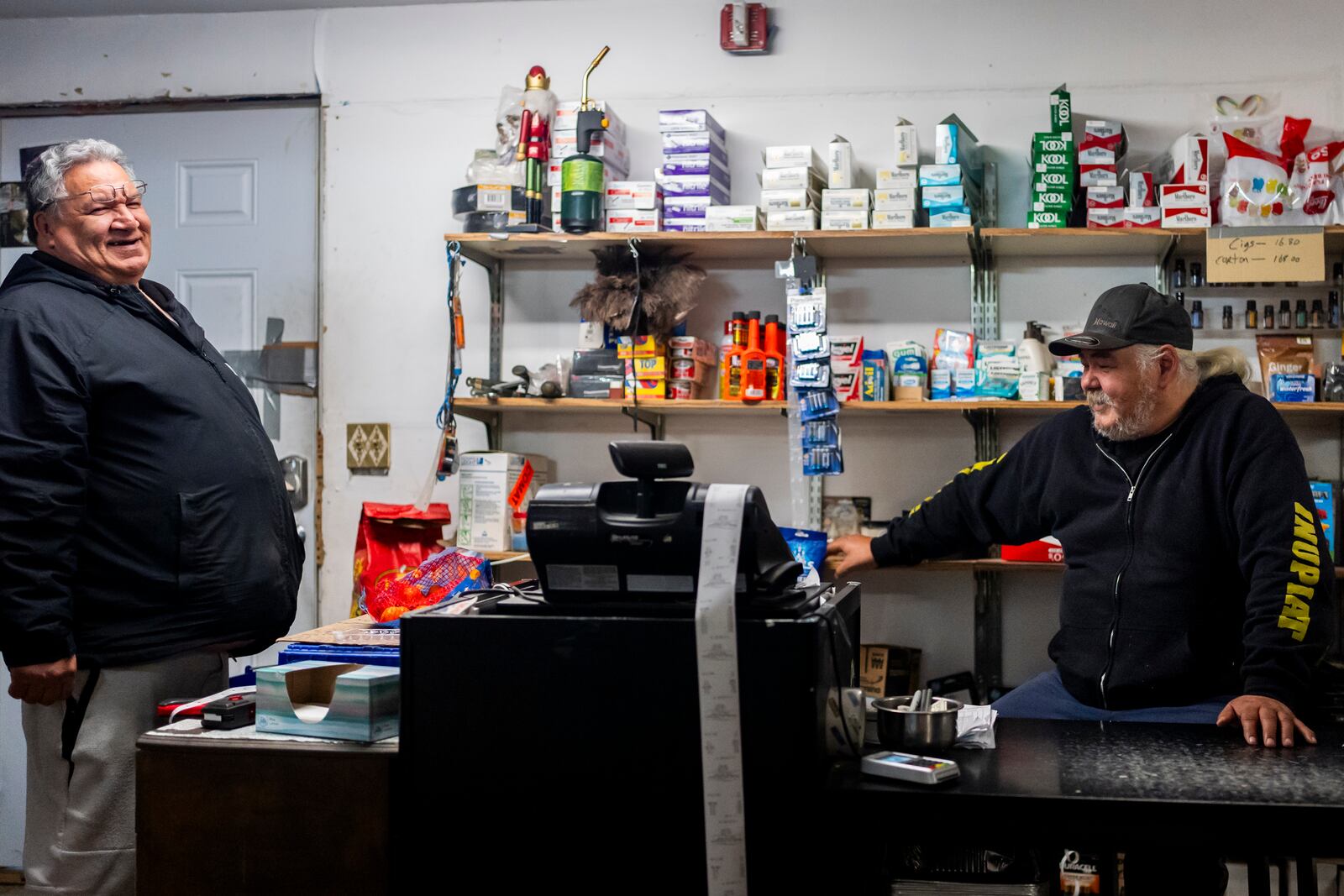 George Kaleak, left, whaling captain and deputy advisor to the North Slope Borough mayor, talks with cashier Kent Sims, right, at Sims Store, one of two small grocery stores in the village in Kaktovik, Alaska, Tuesday, Oct. 15, 2024. (AP Photo/Lindsey Wasson)