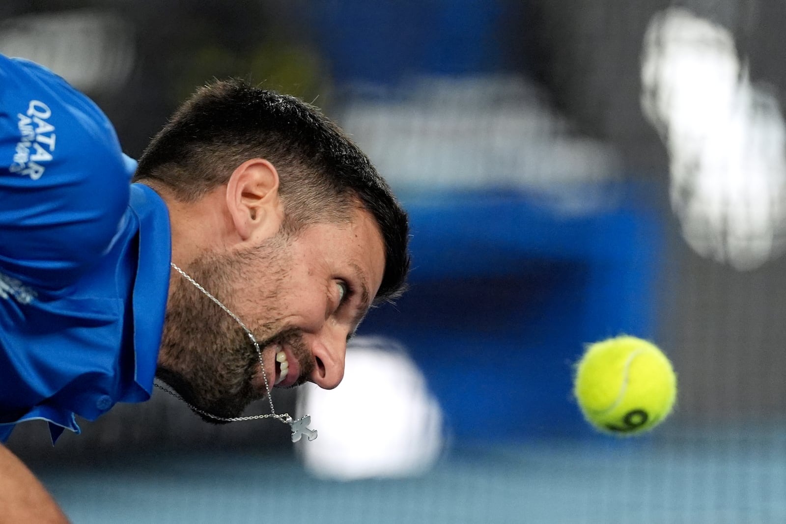 Novak Djokovic of Serbia attempts to play a forehand return to Carlos Alcaraz of Spain during their quarterfinal match at the Australian Open tennis championship in Melbourne, Australia, Tuesday, Jan. 21, 2025. (AP Photo/Ng Han Guan)