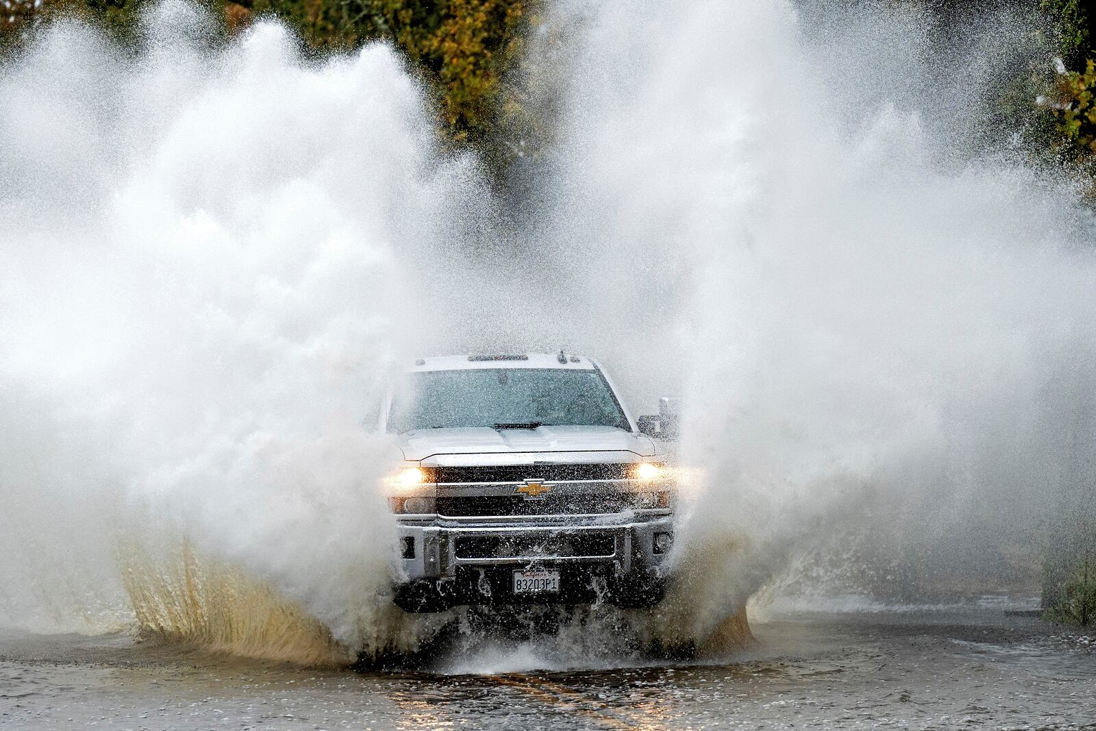 A pick-up truck drives through floodwaters as heavy rains fall in Windsor, Calif., on Friday, Nov. 22, 2024. (AP Photo/Noah Berger)