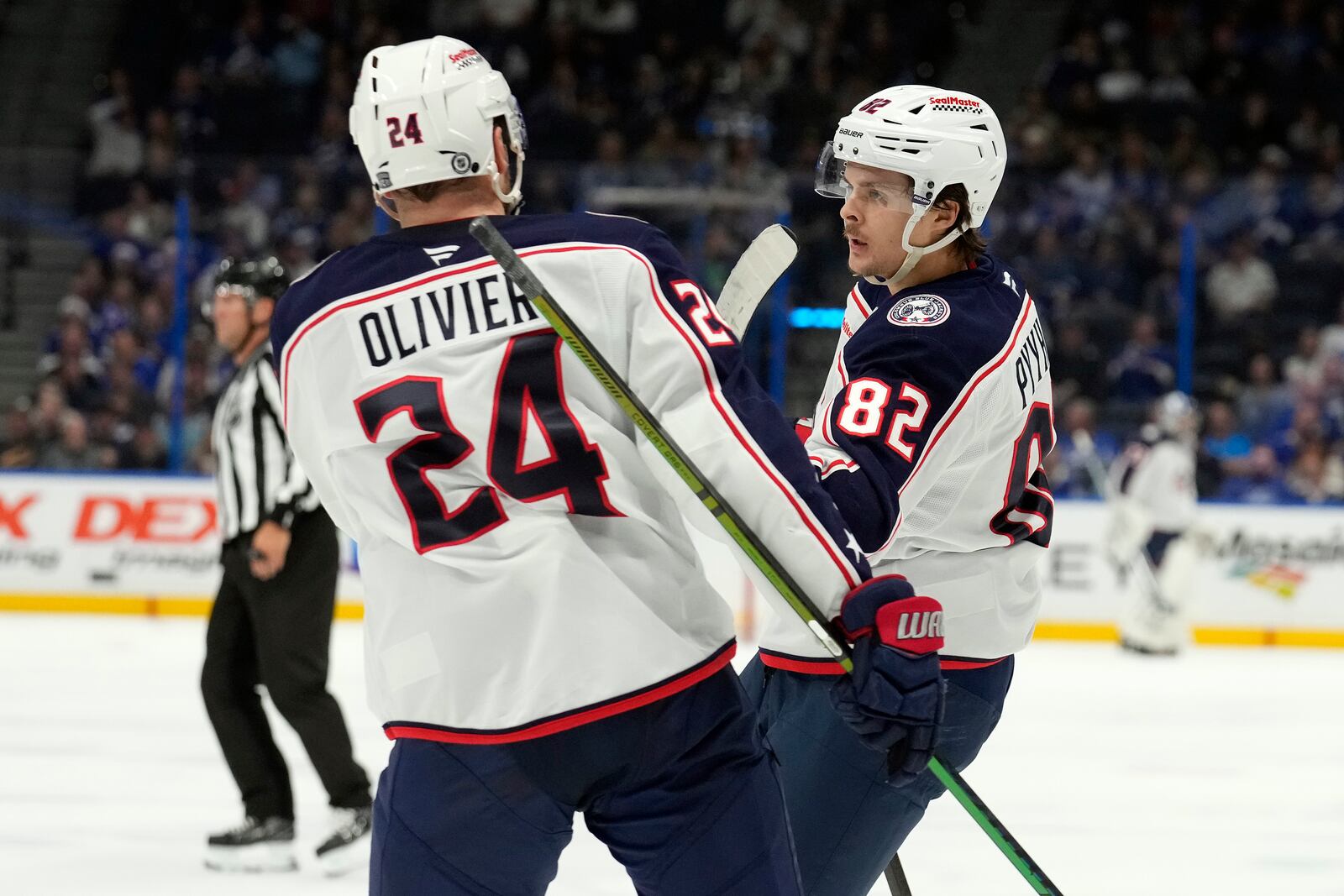 Columbus Blue Jackets left wing Mikael Pyyhtia (82) celebrates his goal against the Tampa Bay Lightning with right wing Mathieu Olivier (24) during the third period of an NHL hockey game Tuesday, Dec. 17, 2024, in Tampa, Fla. (AP Photo/Chris O'Meara)