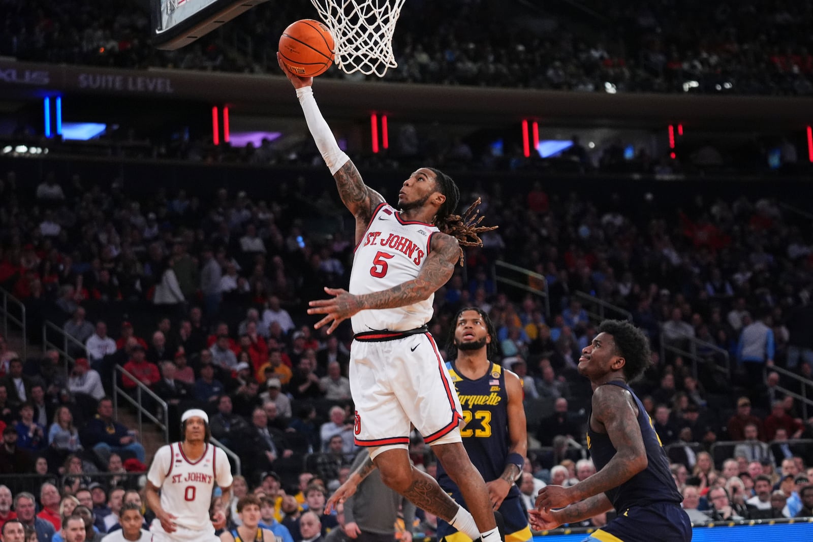 St. John's's Deivon Smith (5) drives past Marquette's Kam Jones (1) and David Joplin (23) during the first half of an NCAA college basketball game in the semifinals of the Big East tournament Friday, March 14, 2025, in New York. (AP Photo/Frank Franklin II)