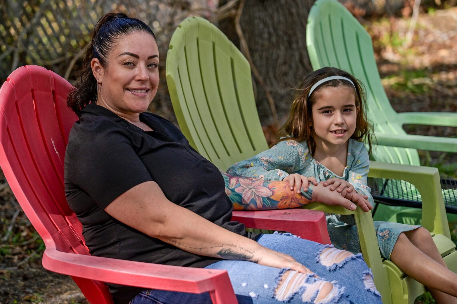 Cecila Grove and her daughter Aria Grove sit outside their home Saturday, Nov. 16, 2024, in Sarasota, Fla. (AP Photo/Steve Nesius)