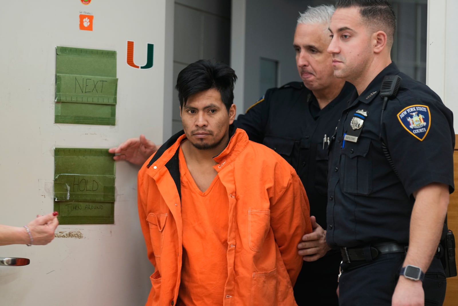 Sebastian Zapeta, accused of burning a woman to death inside a New York City subway train, left, is escorted into Kings County Supreme Court for an arraignment, Tuesday, Jan. 7, 2025, in New York. (AP Photo/Seth Wenig)