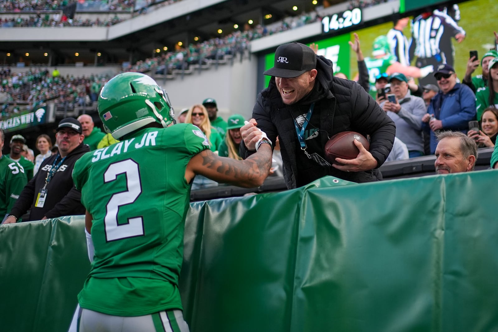 Philadelphia Eagles cornerback Darius Slay Jr. (2) gifts the football to Los Angeles Angels baseball outfielder Mike Trout after recovering a fumble by Dallas Cowboys running back Rico Dowdle during the second half of an NFL football game, Sunday, Dec. 29, 2024, in Philadelphia. (AP Photo/Matt Slocum)