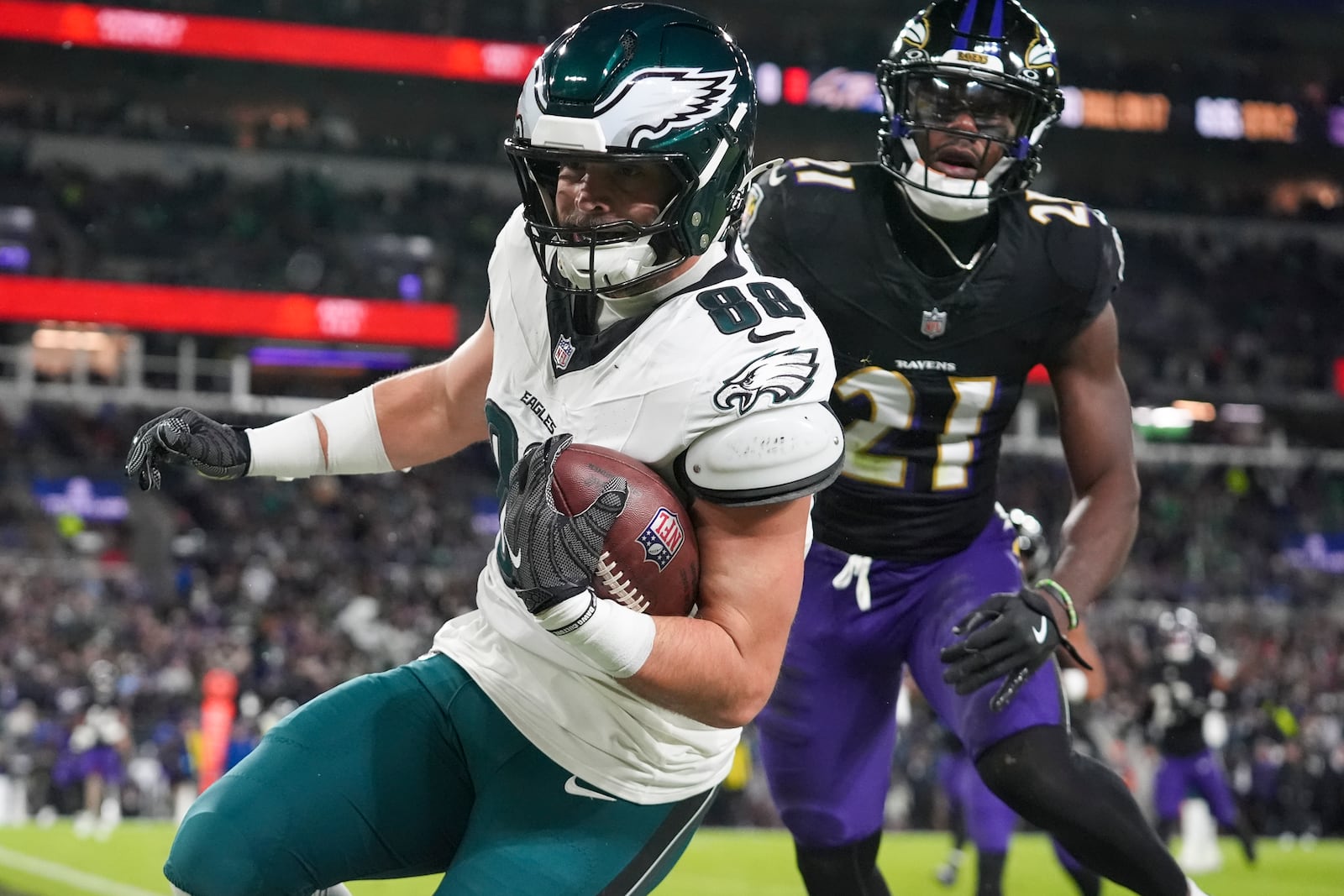 Philadelphia Eagles tight end Dallas Goedert (88) scores a touchdown in front of Baltimore Ravens cornerback Brandon Stephens (21) during the first half of an NFL football game, Sunday, Dec. 1, 2024, in Baltimore. (AP Photo/Stephanie Scarbrough)