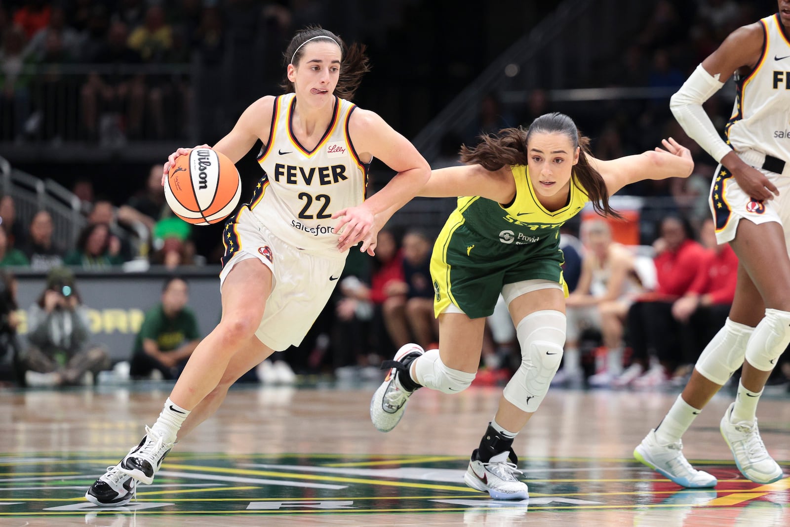 FILE - Indiana Fever guard Caitlin Clark (22) drives as Seattle Storm guard Nika Muhl defends during the second half of a WNBA basketball game, Wednesday, May 22, 2024, in Seattle. (AP Photo/Jason Redmond, File)