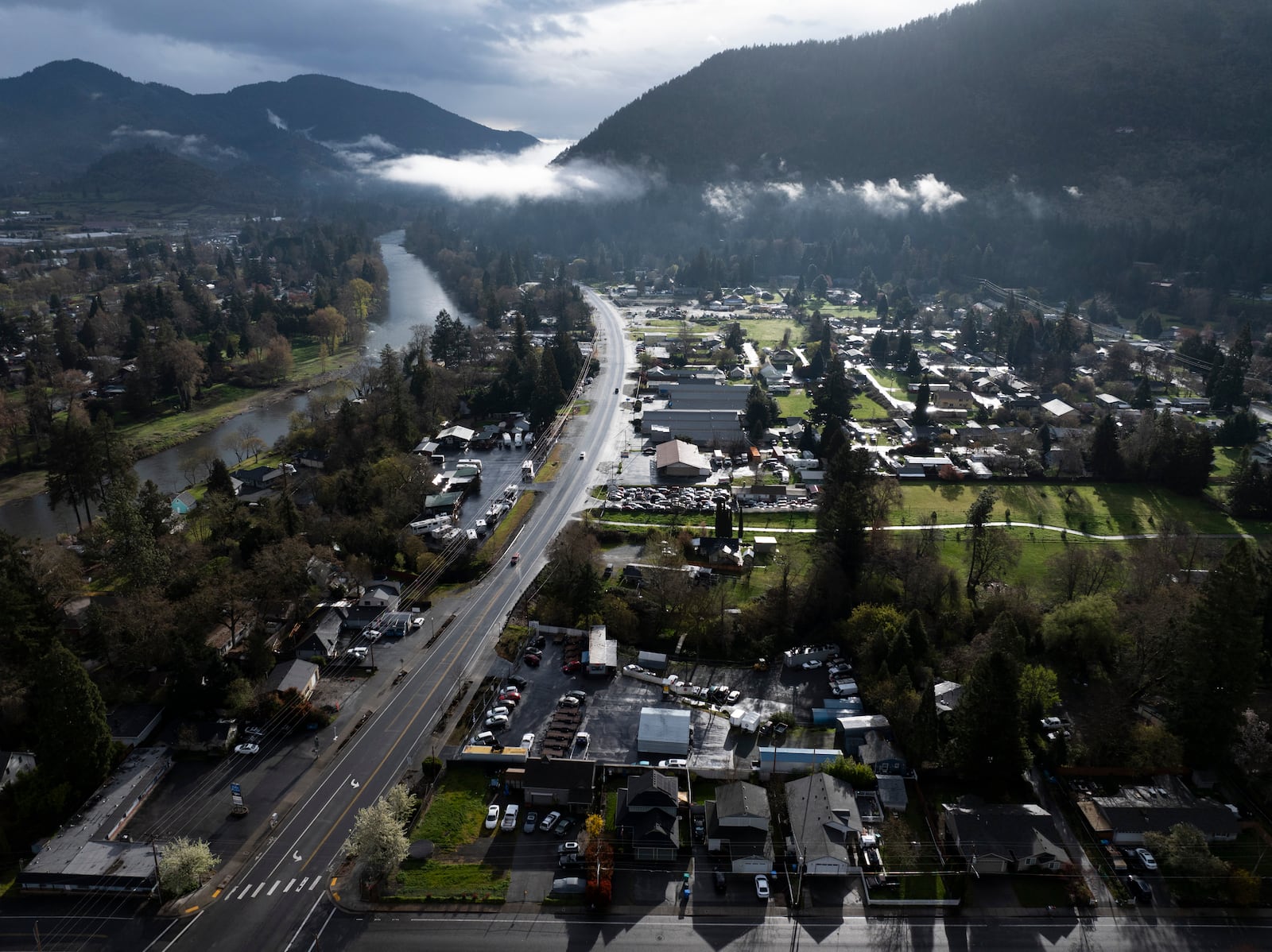 FILE - Vehicles drive down Rogue River Highway as light shines on the area March 23, 2024, in Grants Pass, Ore. (AP Photo/Jenny Kane, File)