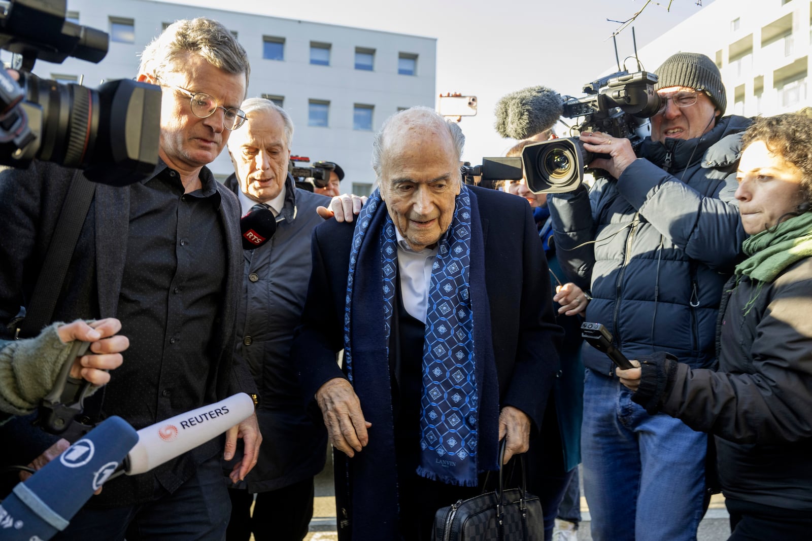 Ex-FIFA President Sepp Blatter, center, arrives in front of the special appeals court in Muttenz, Switzerland, for his retrial on fraud, forgery and misappropriation charges Monday, March 3, 2025. (Urs Flueeler/Keystone via AP)10