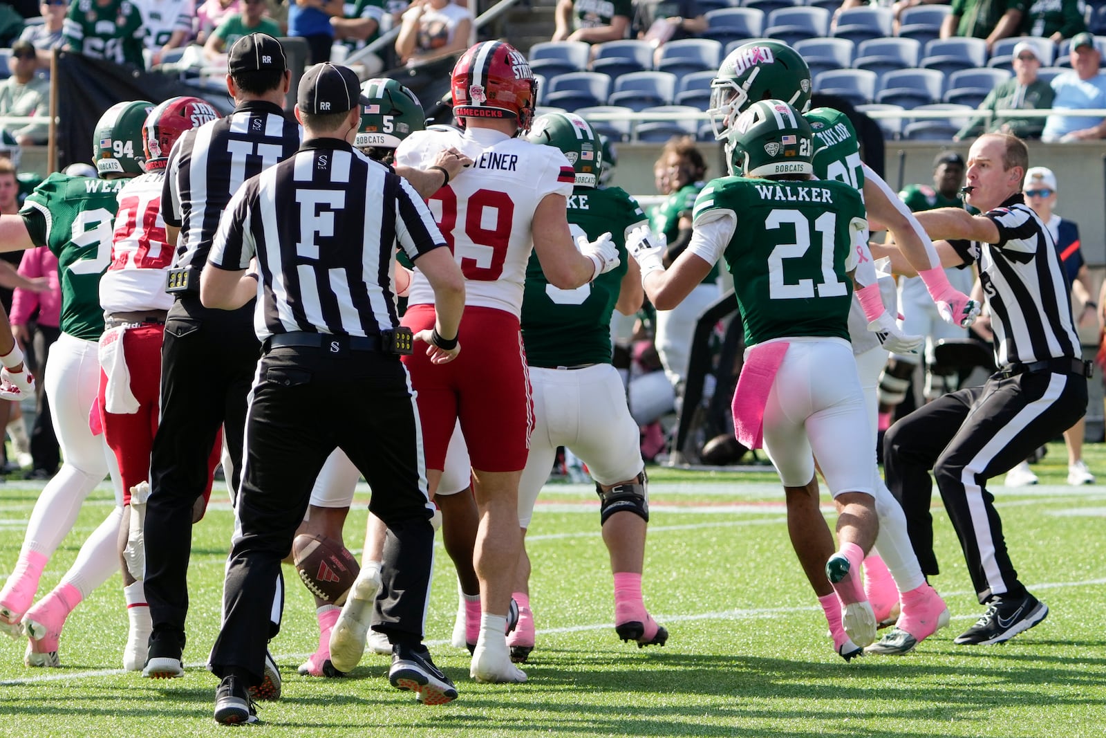 Officials break up a scuffle between Jacksonville State and Ohio players during the first half of the Cure Bowl NCAA college football game, Friday, Dec. 20, 2024, in Orlando, Fla. (AP Photo/John Raoux)