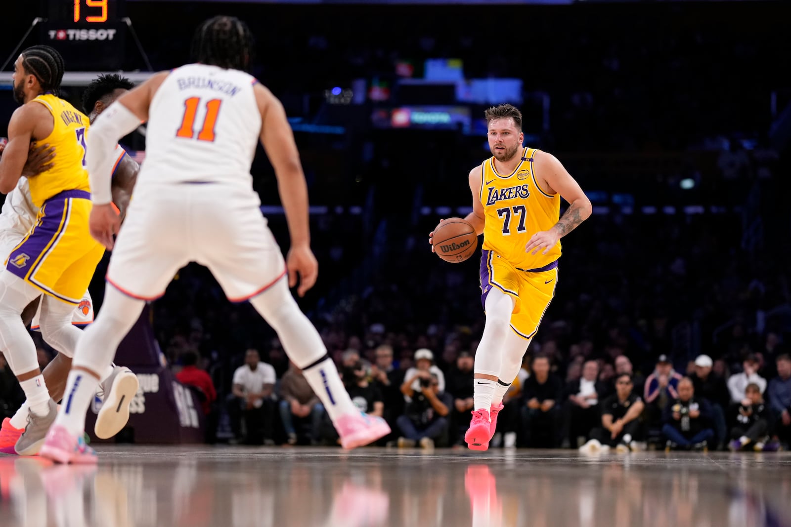 Los Angeles Lakers guard Luka Doncic, right, dribbles as New York Knicks guard Jalen Brunson waits for him during the first half of an NBA basketball game Thursday, March 6, 2025, in Los Angeles. (AP Photo/Mark J. Terrill)