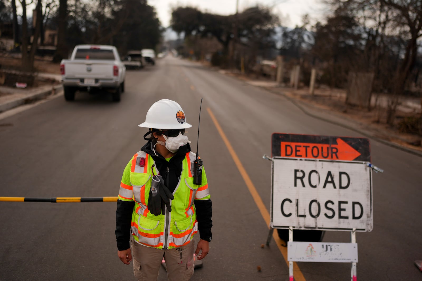 Emeralda Urena works at a check point leading to the damage zone of the Eaton Fire Friday, Jan. 17, 2025 in Altadena, Calif. (AP Photo/Jae C. Hong)