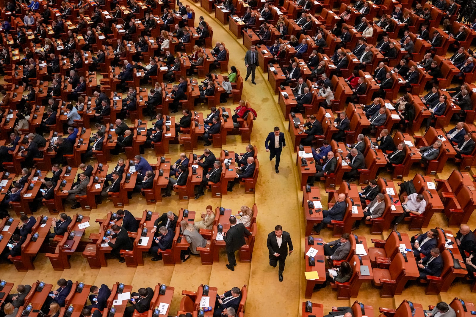 Newly elected members of parliament attend a confidence vote for Romanian Prime Minister designate Marcel Ciolacu, the leader of the Social Democratic party, and his team, at the parliament in Bucharest, Romania, Monday, Dec. 23, 2024. (AP Photo/Vadim Ghirda)