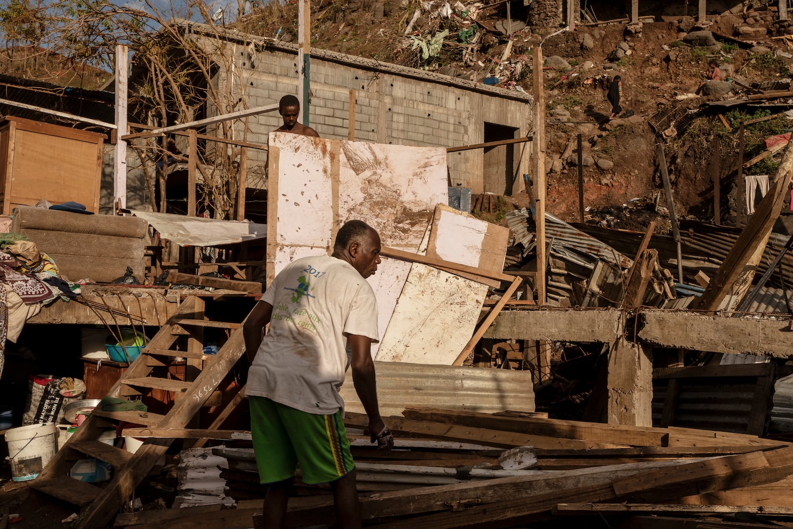 A man starts rebuilding his shack in the Kaweni slum on the outskirts of Mamoudzou, in the French Indian Ocean island of Mayotte, Thursday, Dec. 19, 2024, after Cyclone Chido. (AP Photo/Adrienne Surprenant)