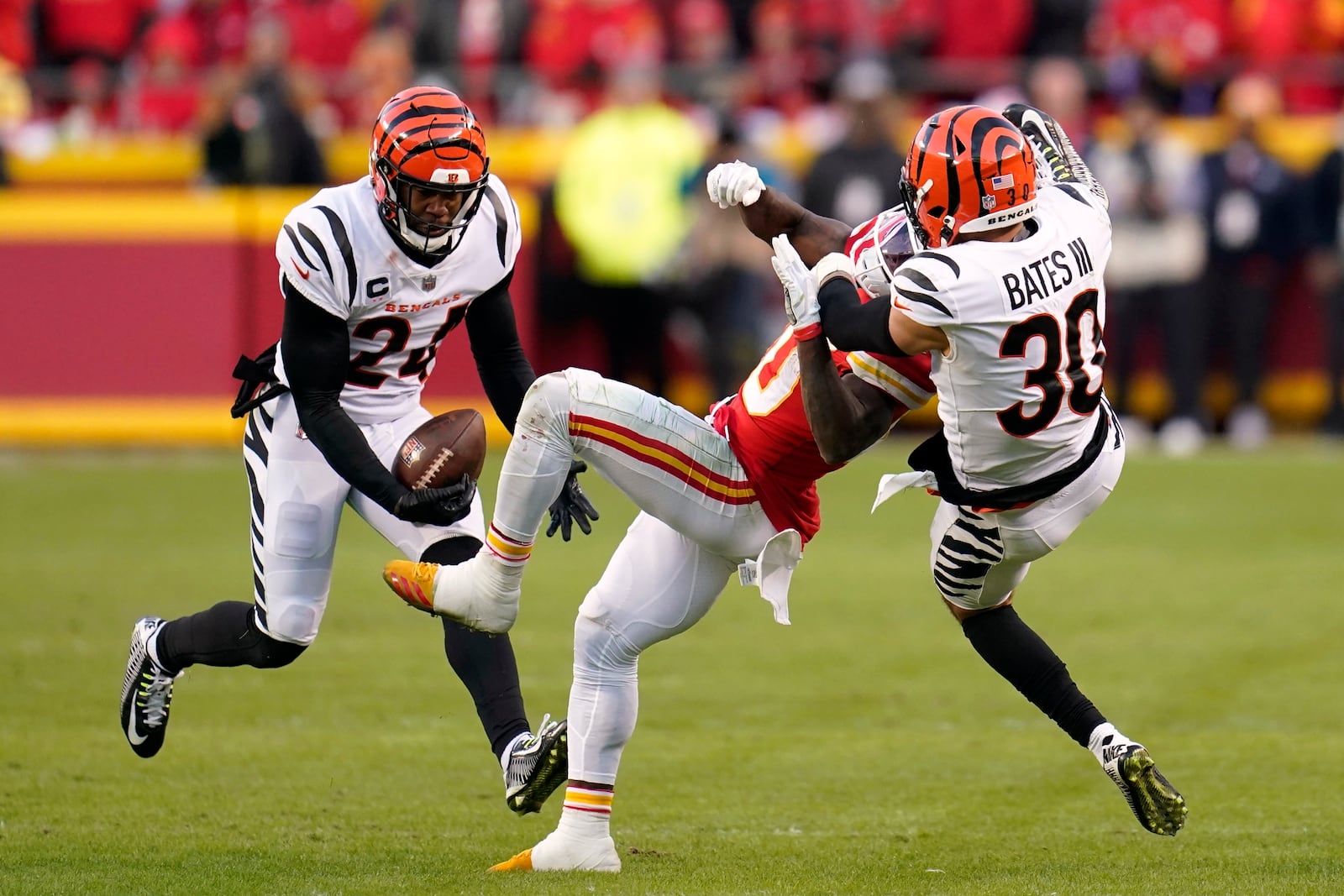 Cincinnati Bengals safety Vonn Bell (24) intercepts a pass intended for Kansas City Chiefs wide receiver Tyreek Hill, center, as Bengals free safety Jessie Bates (30) defends during overtime in the AFC championship NFL football game, Sunday, Jan. 30, 2022, in Kansas City, Mo. The Bengals won 27-24. (AP Photo/Paul Sancya)