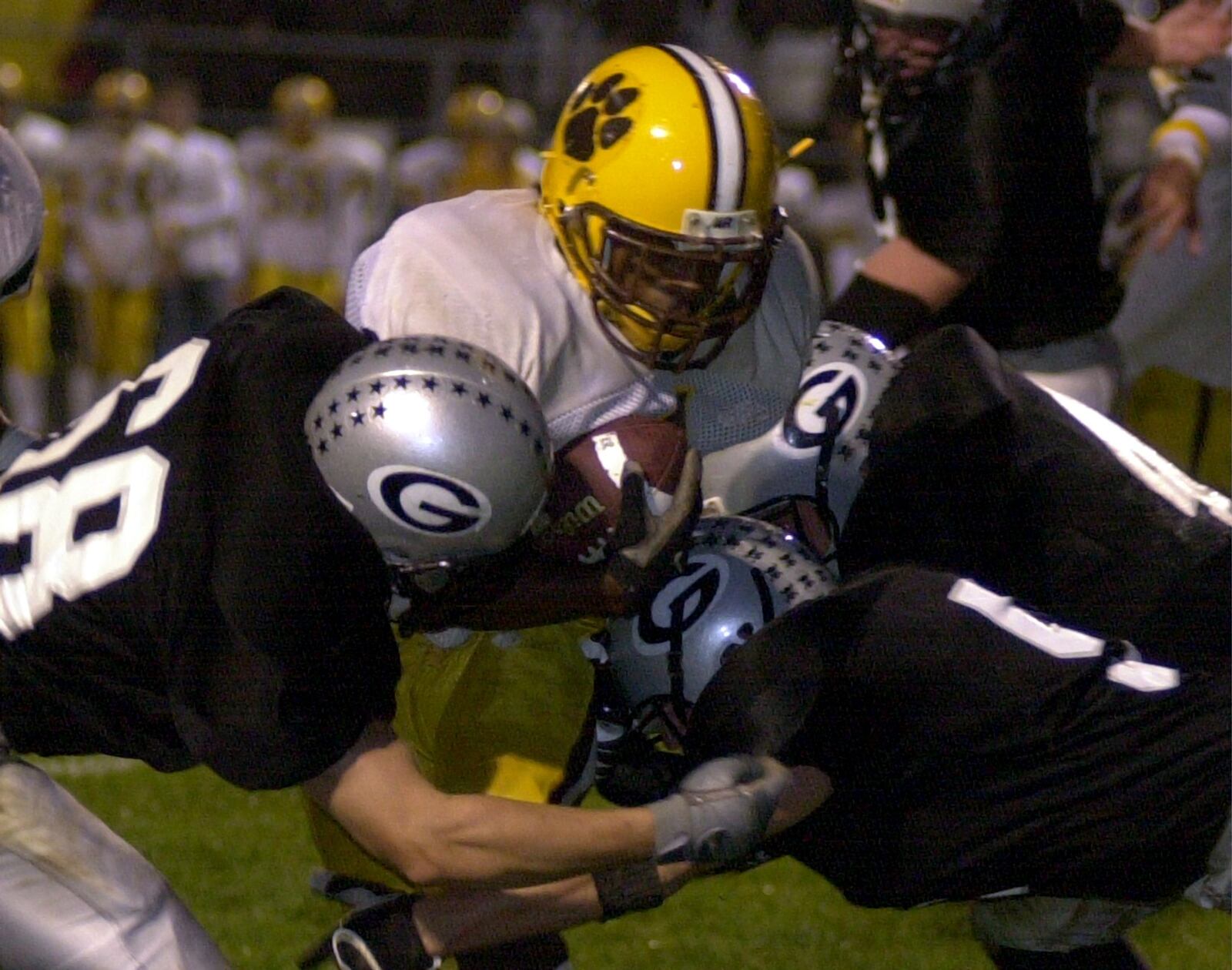 Grahams’ Adam Zimmerman (L), Tyler Schlater (R), and Austin Roseberry try to stop the progress of Kenton Ridge’s Brandon Nicholson friday night at Graham.