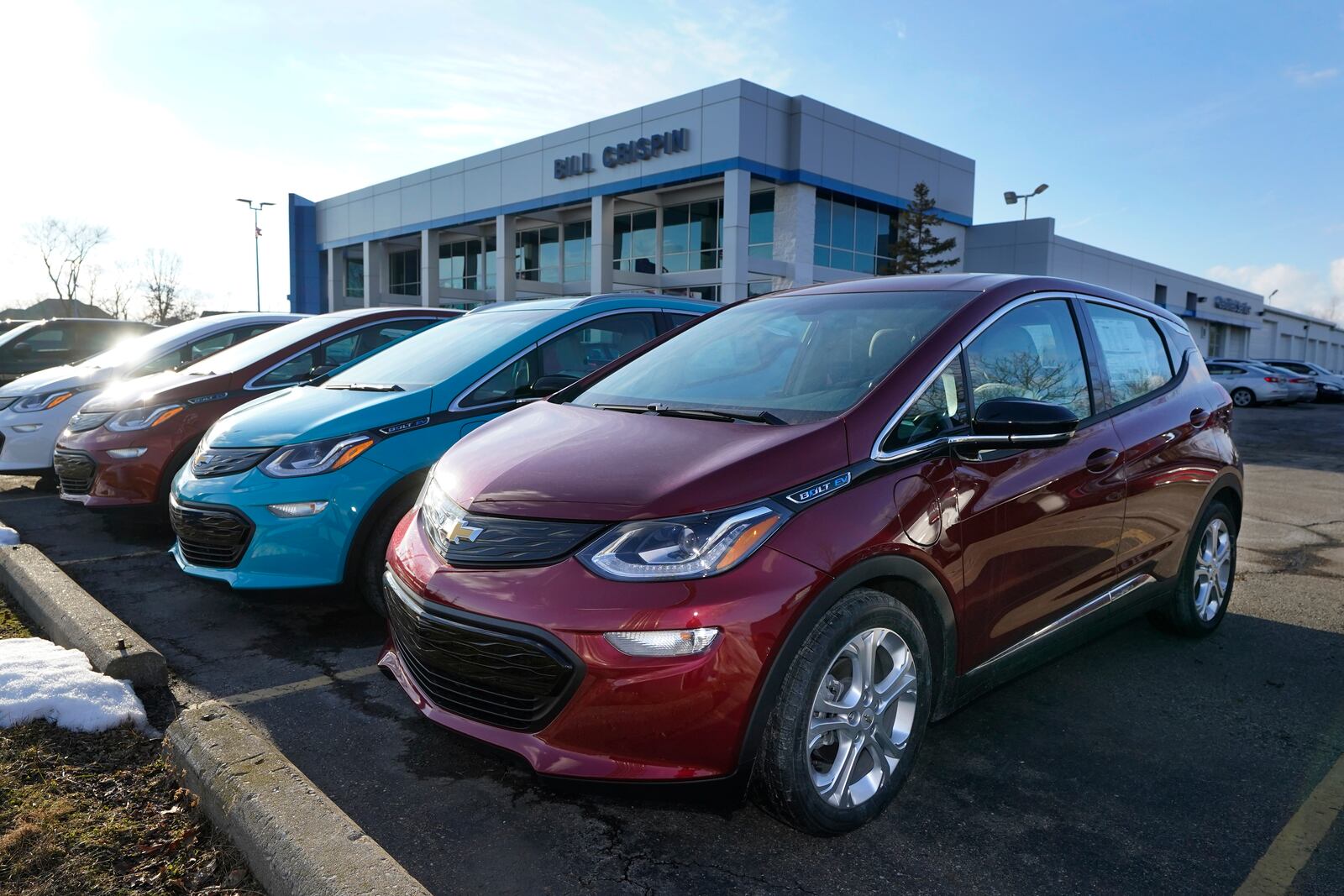 A 2021 Chevrolet Bolt EV, is displayed with 2020 models at Bill Crispin Chevrolet Thursday, Feb. 25, 2021, in Saline, Mich. Opinion polls show that most Americans would consider an EV if it cost less, there were more charging stations along freeways, and if automakers offered a bigger variety of models. (AP Photo/Carlos Osorio)