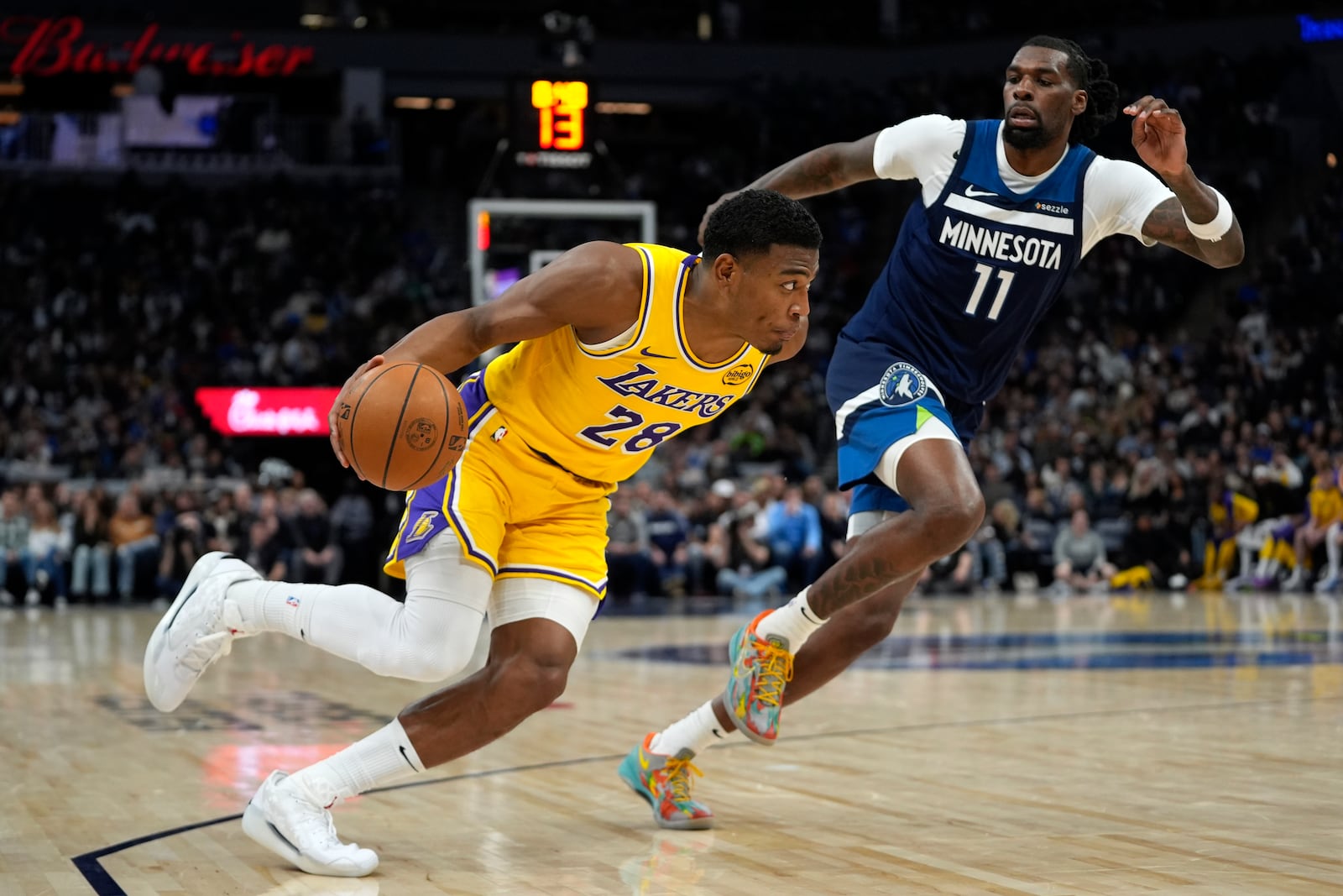 Los Angeles Lakers forward Rui Hachimura (28) works toward the basket as Minnesota Timberwolves center Naz Reid (11) defends during the second half of an NBA basketball game, Friday, Dec. 13, 2024, in Minneapolis. (AP Photo/Abbie Parr)