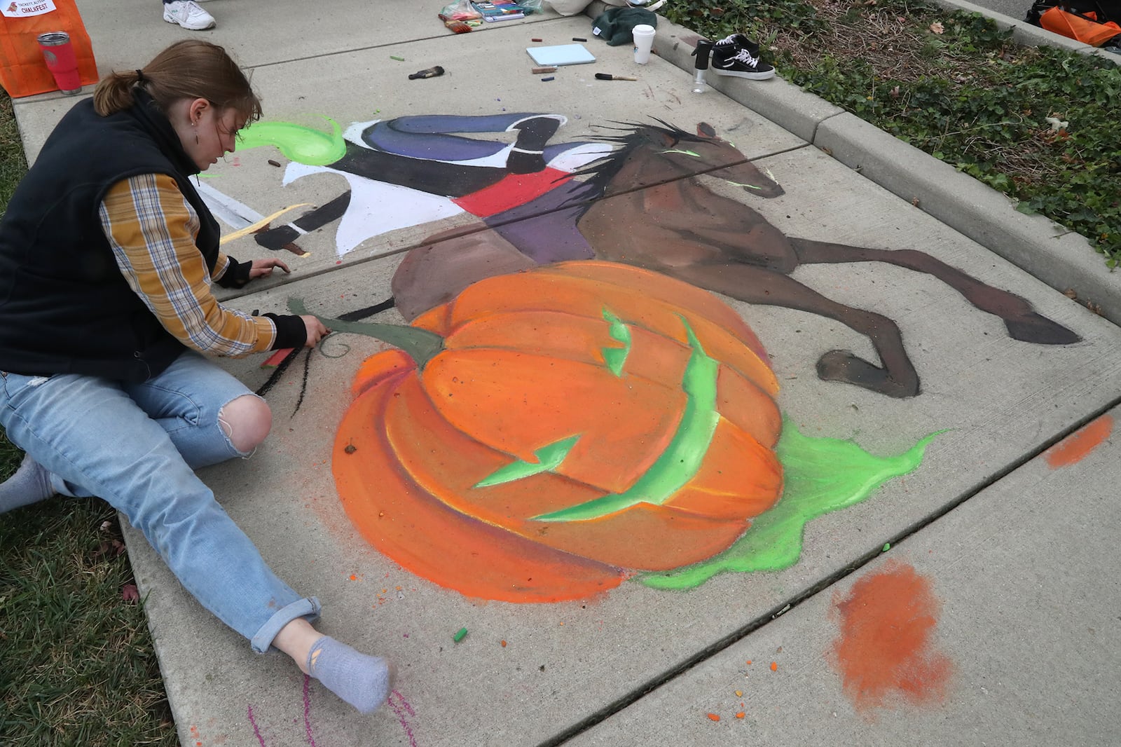 Alyssa Tackett works on her chalk artwork during the National Trail Parks and Recreation District's annual ChalkFest Saturday, Oct. 1, 2022 at National Road Commons Park. BILL LACKEY/STAFF