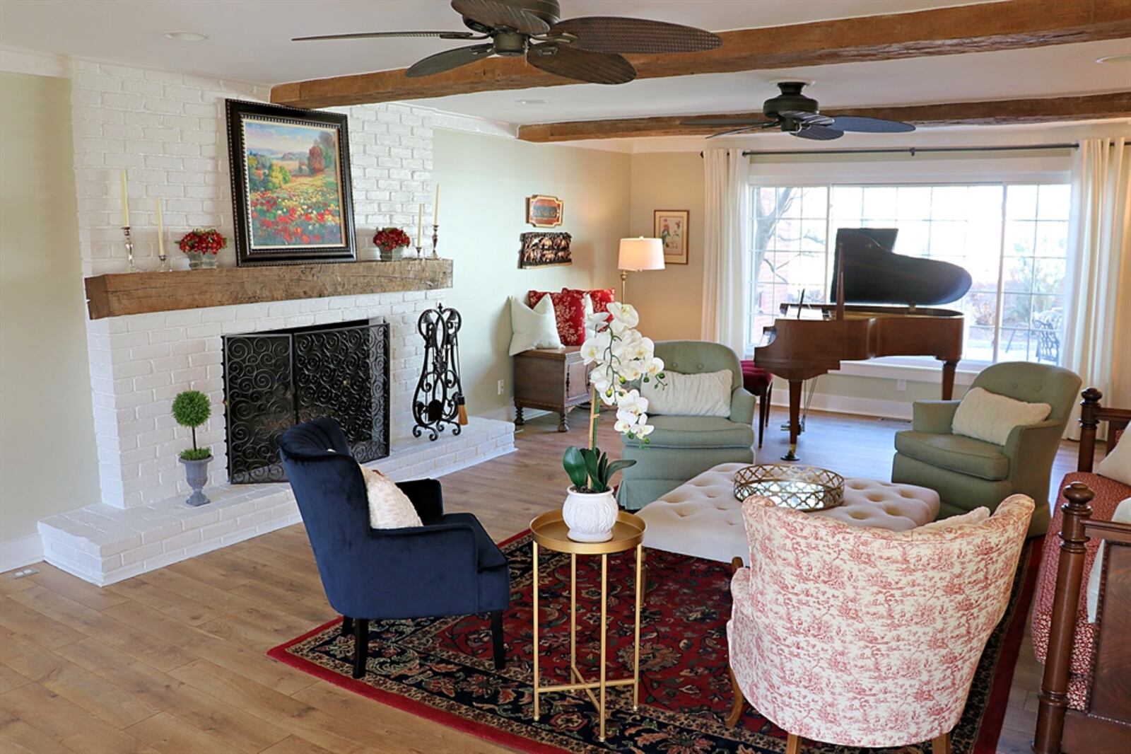 A painted brick fireplace has a brick hearth and matching wood-beam mantel. 