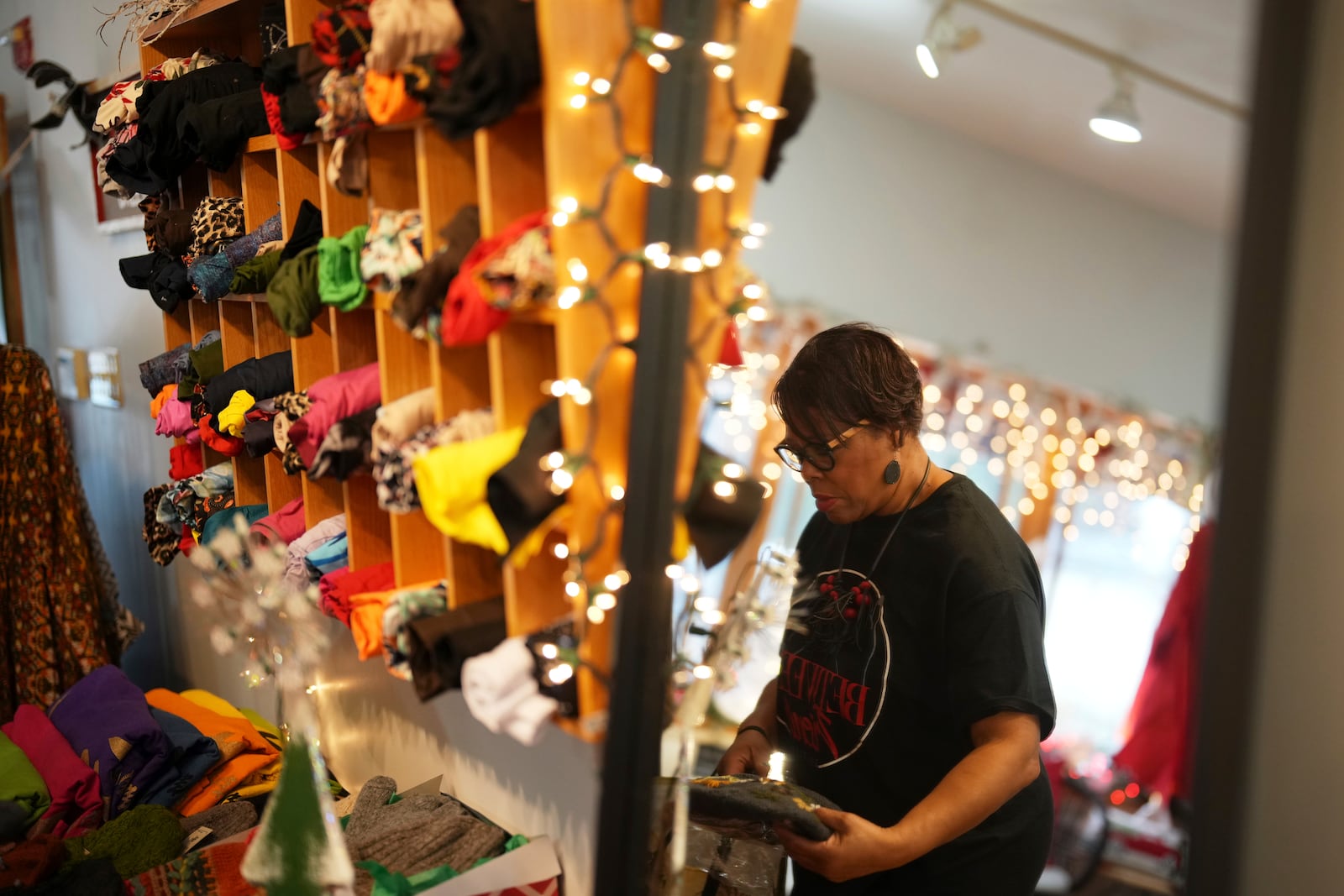 Claudia Averette lays out clothing at her shop, Between Friends Boutique, Wednesday, Dec. 11, 2024, in Philadelphia. (AP Photo/Matt Slocum)