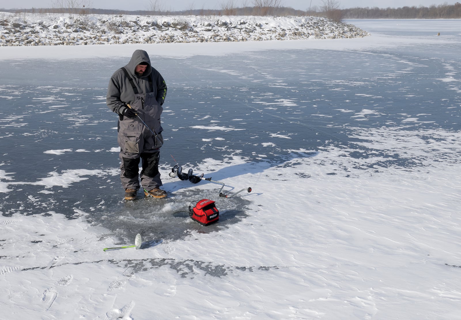 Jeremy Child braves the below zero wind chill as he stands over his fishing hole in the ice at C.J. Brown Reservoir  Tuesday, Jan. 21, 2025. BILL LACKEY/STAFF