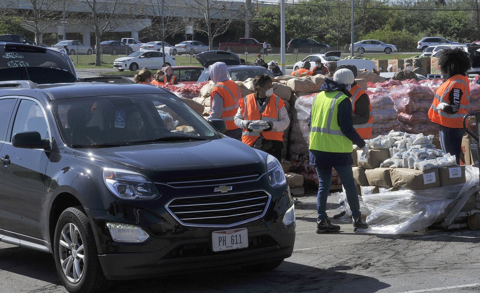 Volunteers and members of the National Guard load food into vehicles at Wright State's Nutter Center on Tuesday morning. The Foodbank was distributing food to Greene County residents. MARSHALL GORBY/STAFF