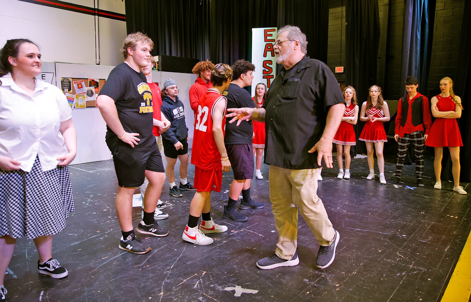 Bryan Szekacs directs students as they rehearse for "High School Musical" Friday, April 19, 2024. This weekend's musical marks the 25th and last time Szekacs will direct the students in a performance. BILL LACKEY/STAFF